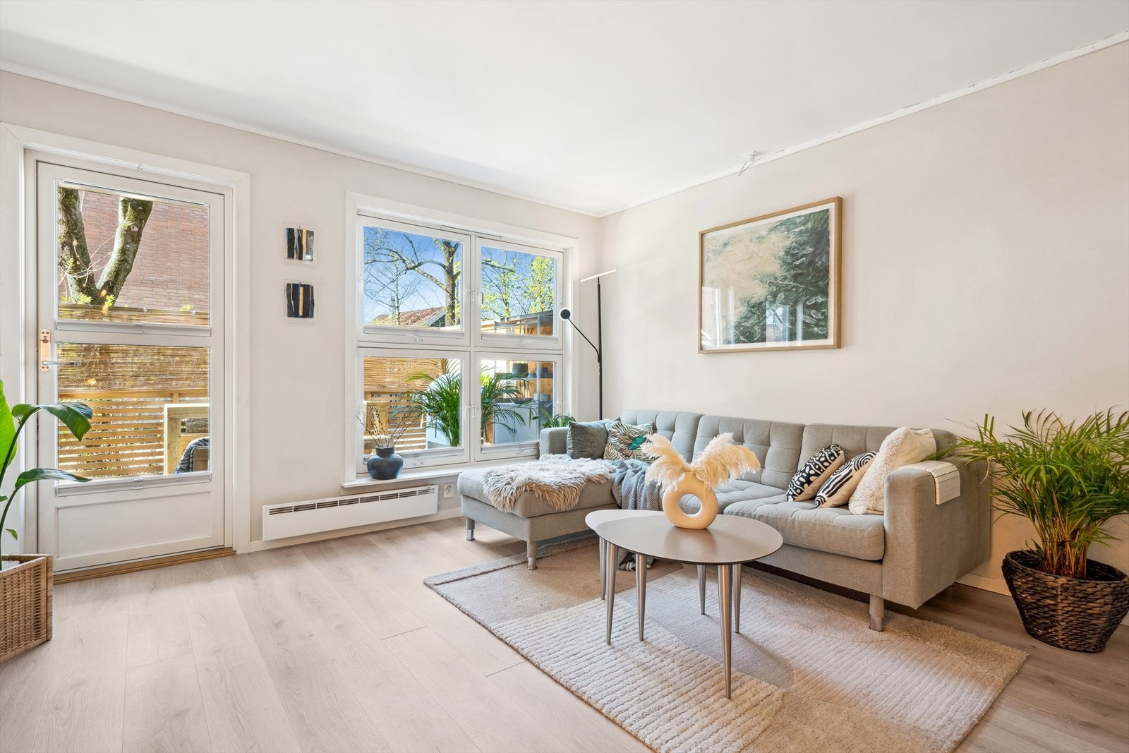 Romslig og pen stue med laminatgulv fra 2025 og lysmalte vegger, også fra 2025. Galleribilde