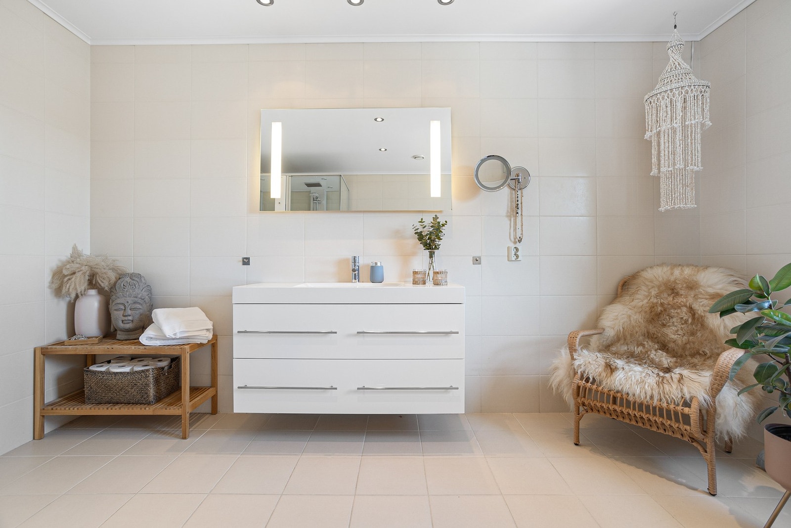 Badet i underetasjen har fliser på vegger og gulv. Utstyrt med dusjhjørne, veggmontert toalett, servant, badekar og varme i gulv. Galleribilde