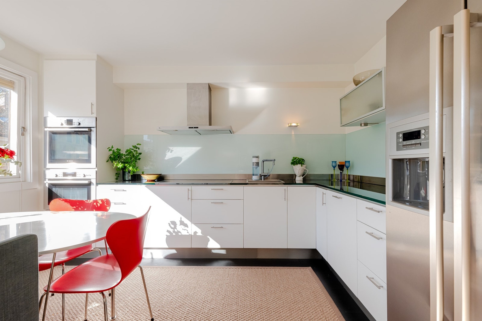 Kjøkkeninnredningen har glatte fronter fra 2024 og en elegant benkeplate av glass, som gir et moderne og sofistikert uttrykk. Galleribilde