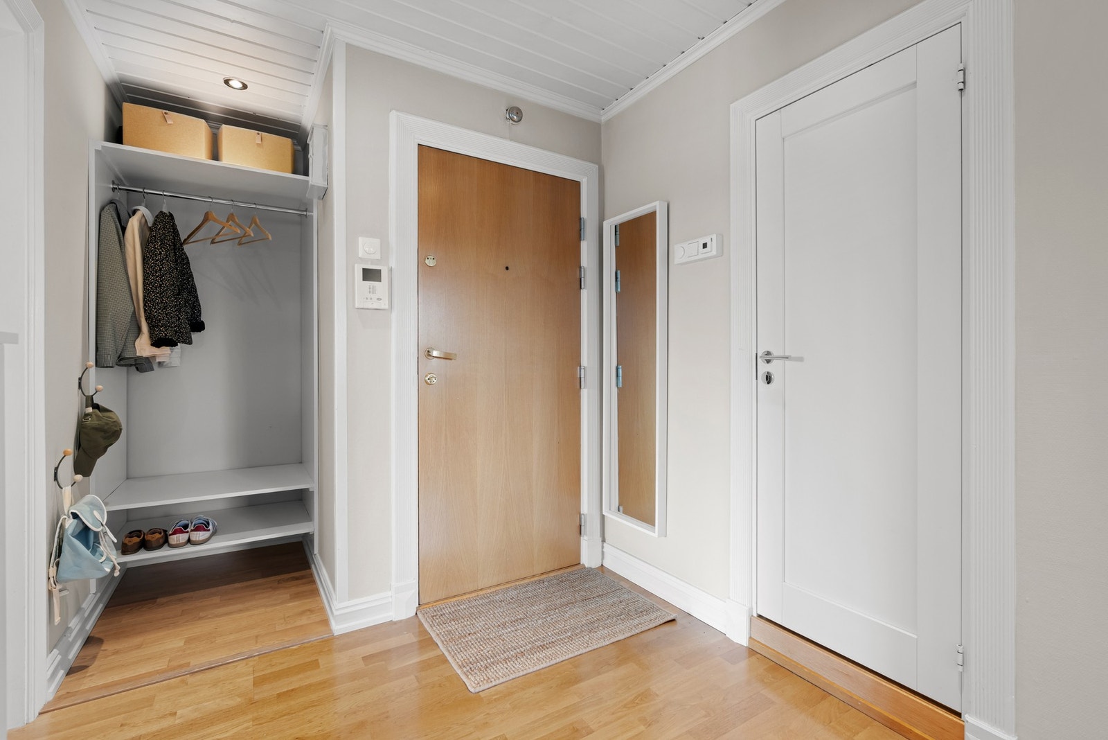 Rosmlig entré med god plass for sko og ytterklær i egen nisje. Dørcalling med kamera er installert ved inngangsdøren. Galleribilde