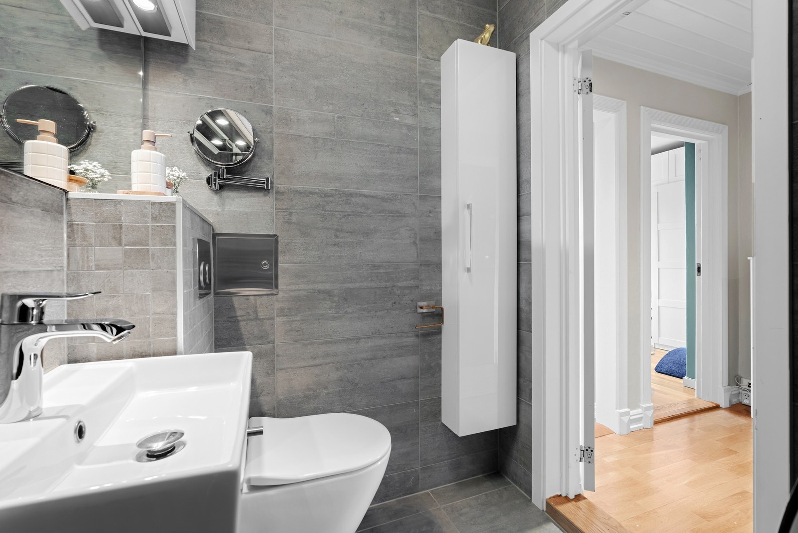 Baderomsinnredningen består av servant, stort speil med overlyskasse, vegghengt wc, dusjhjørne med foldedør og opplegg for vaskemaskin. I tillegg har borettslaget fellesvaskeri. Galleribilde