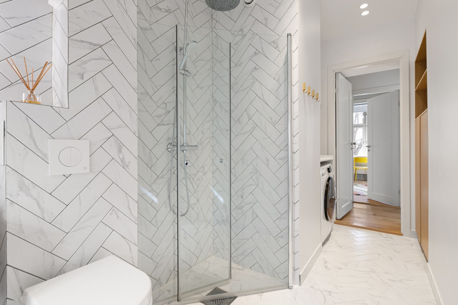 Badet er innredet med vegghengt toalett, servantskap med speil og belysning, samt romslig dusjhjørne med innfellbare glassdører og regnfallsdusj. Galleribilde