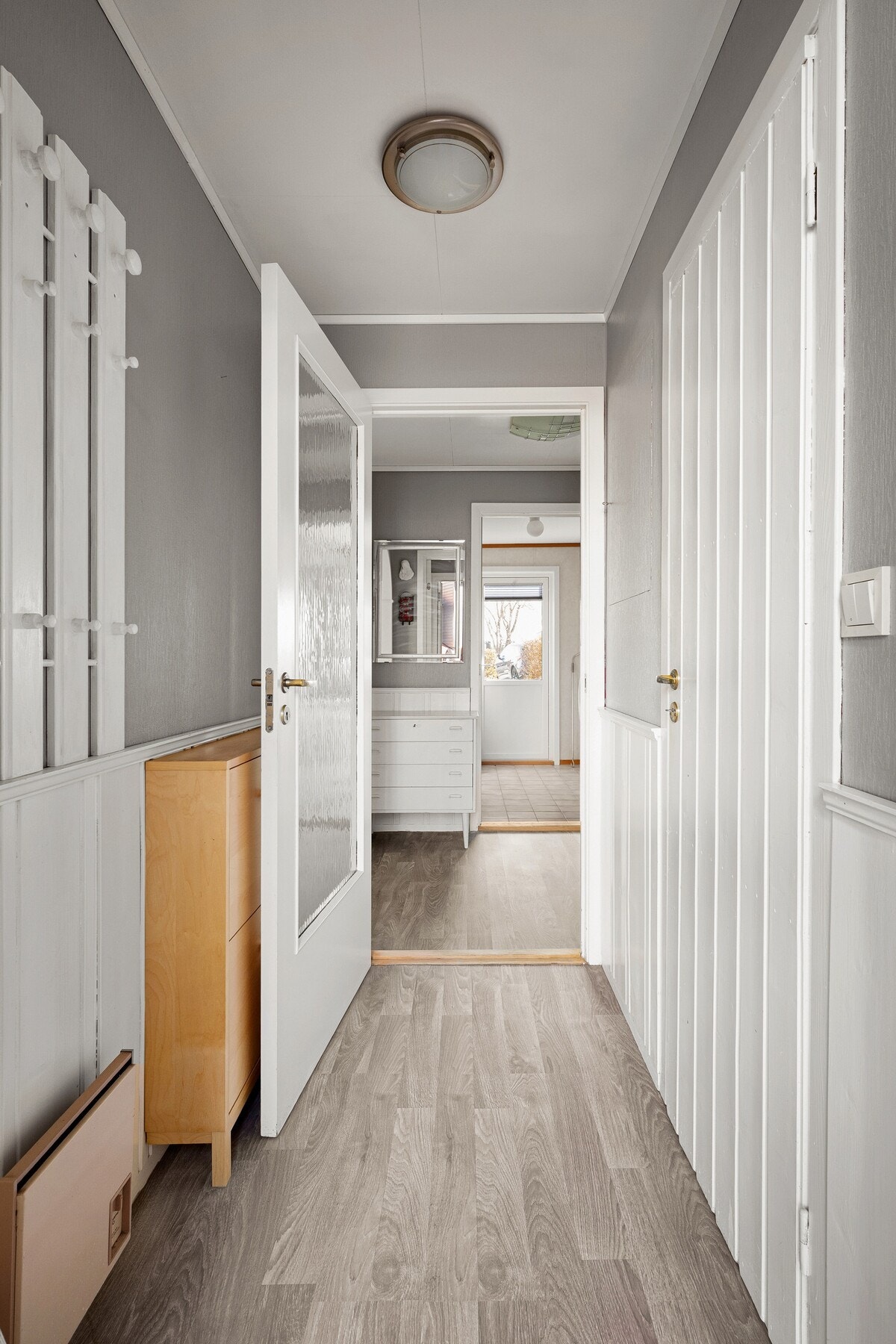 Når du kommer inn i boligen, møtes du av en lys og innbydende entré med garderobeskap som gir praktisk oppbevaring for yttertøy og sko. Galleribilde