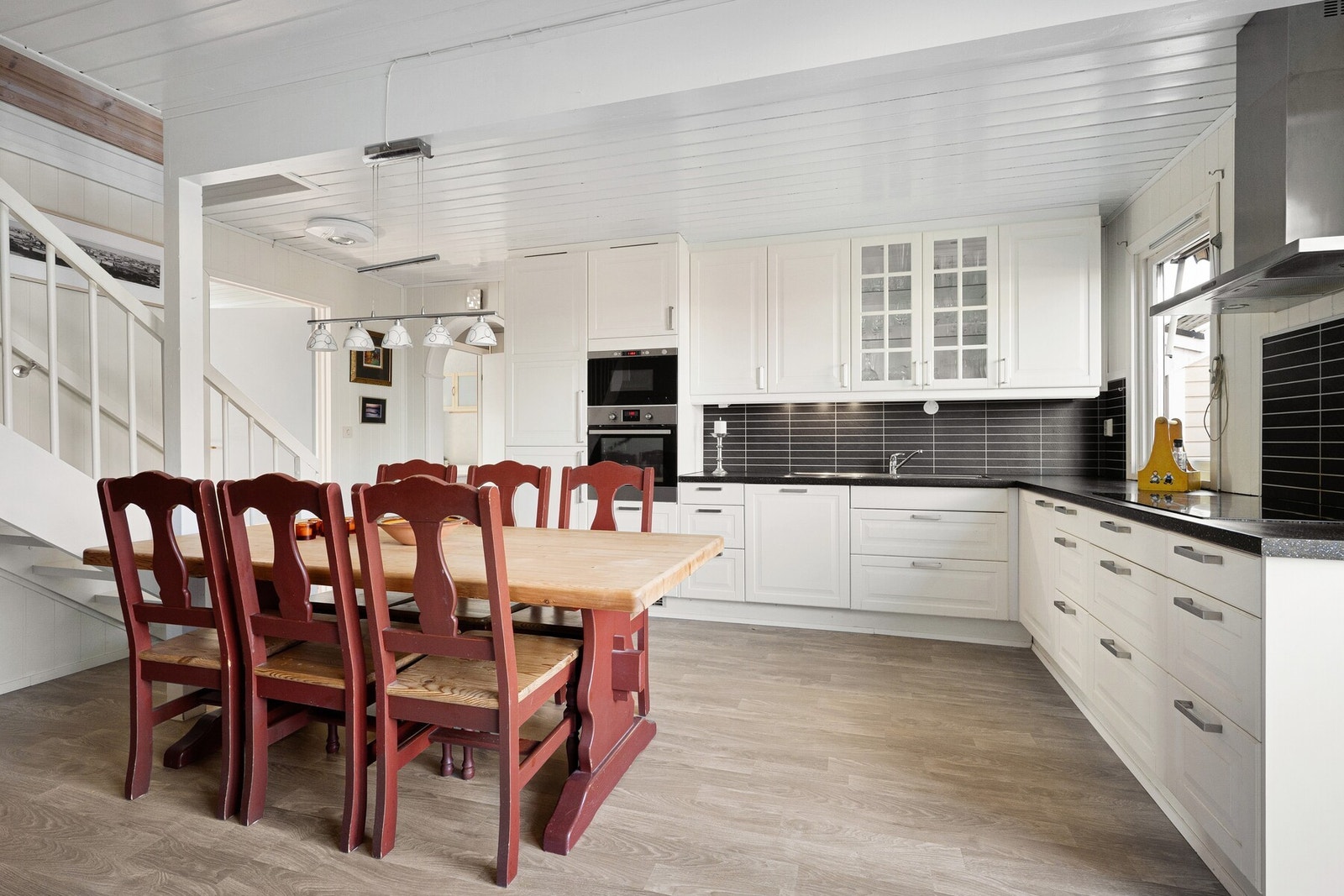 Innredningen har klassiske profilerte fronter, og benkeplaten er i laminat med flismønstret kjøkkenplate mellom overskap og benk. Galleribilde