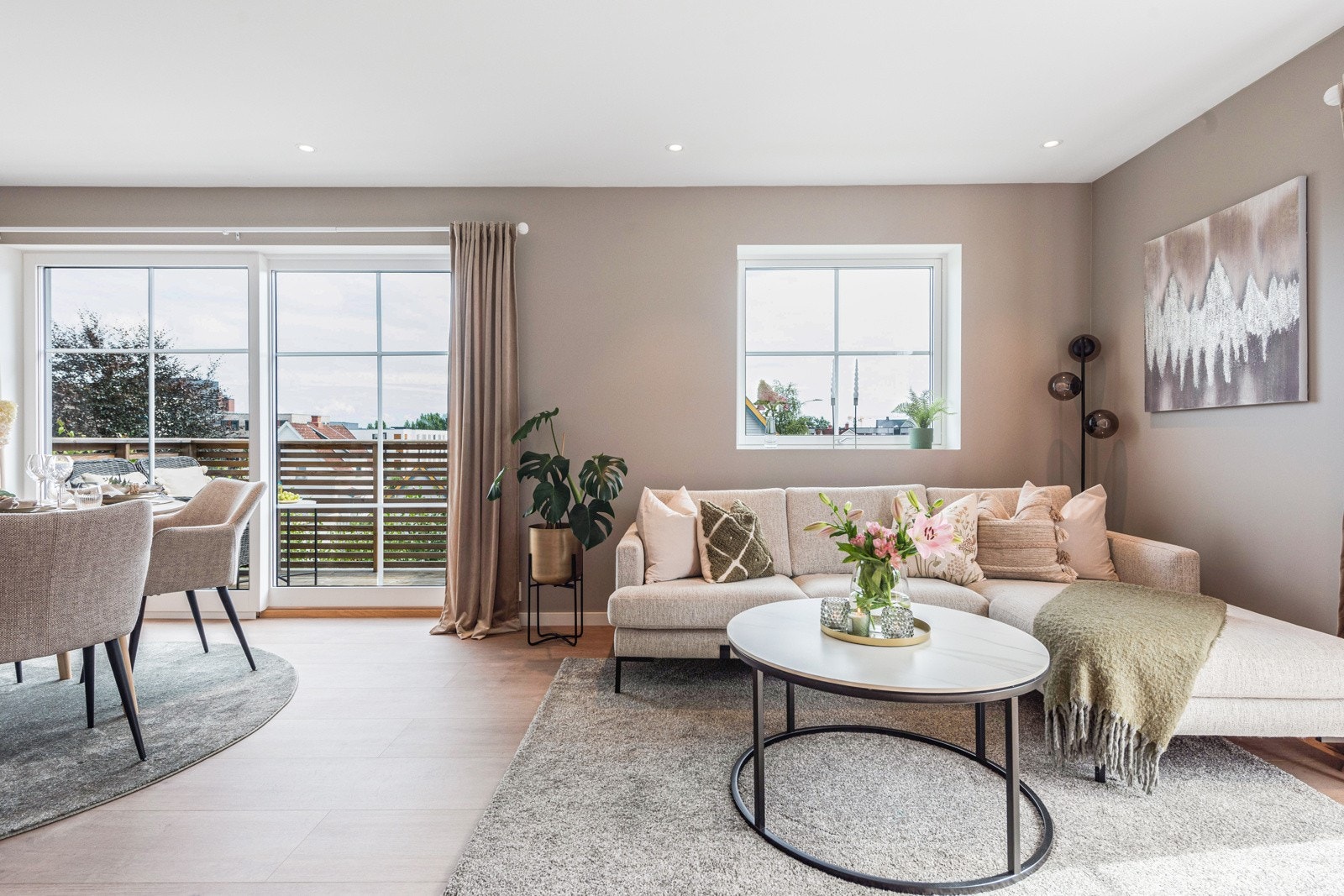 Delikate vegger malt i beige, listefri himling med downlights, enstavs laminatgulv og hvite sprosser på vindusflatene skaper en klassisk, fin helhet. Galleribilde