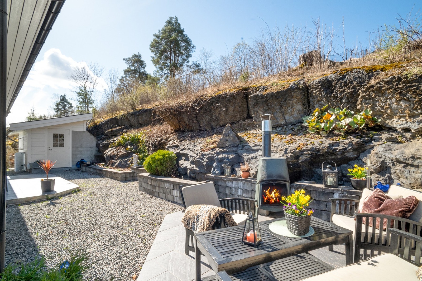 På baksiden av huset er det etablert en deilig uteplass med peis. Her nyter man ettermiddagssolen. Galleribilde