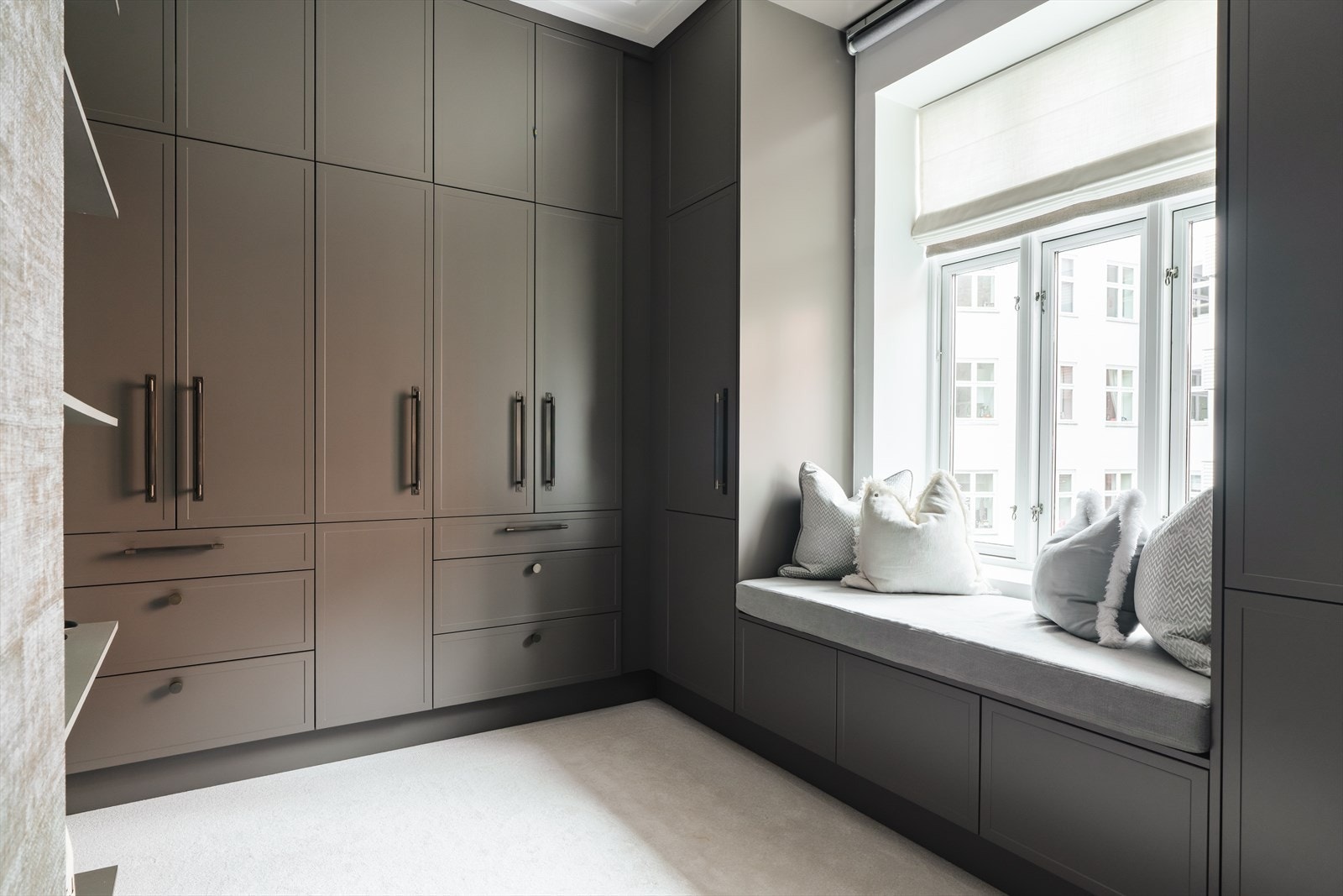 Walk-in-closet med koselig sitteplass ved vinduet. Galleribilde