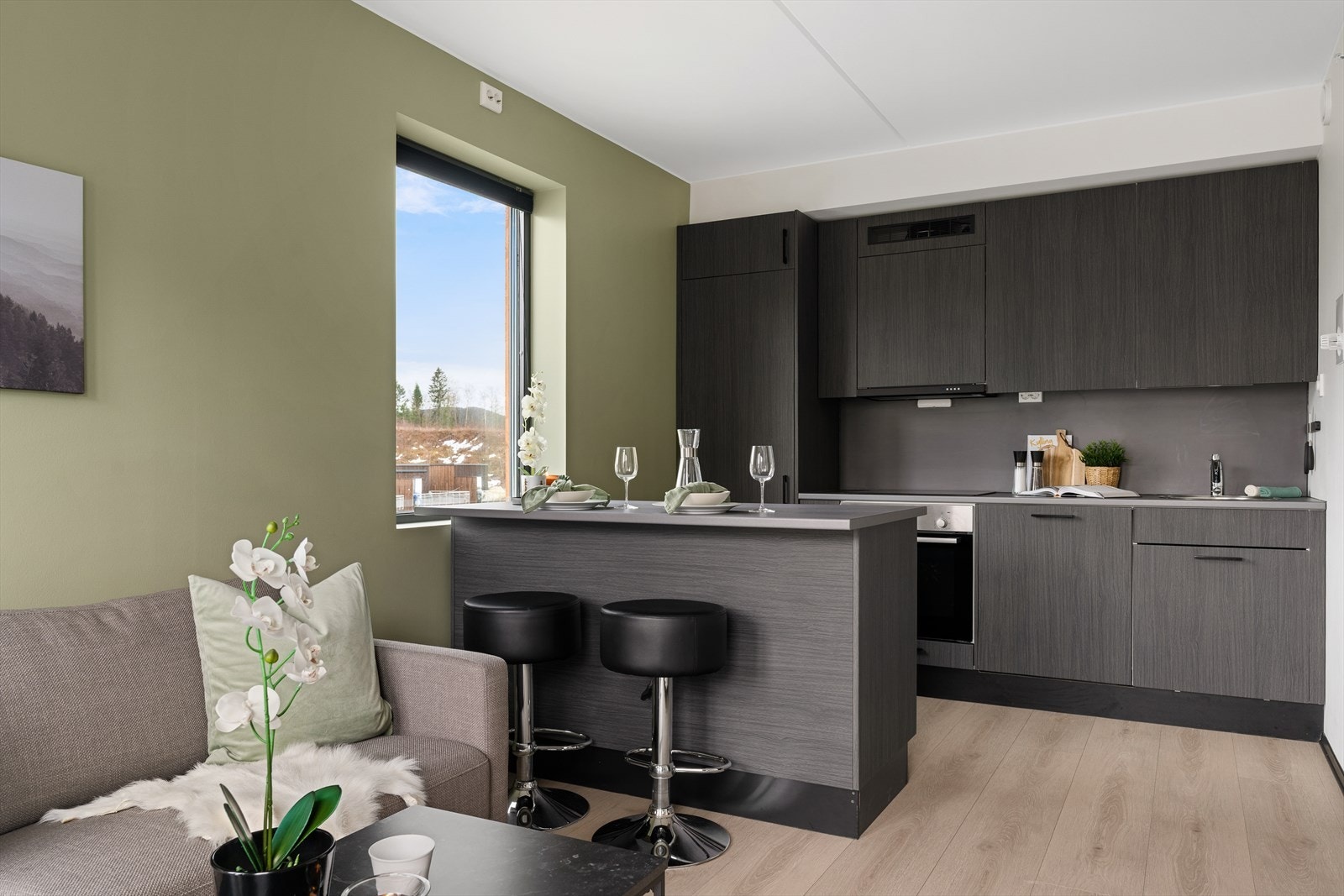 Lekker, tidløs kjøkkeninnredning med slette fronter og benkeplate i laminat. Kjøkkenøy for ekstra oppbevaring og benkeplass. Galleribilde