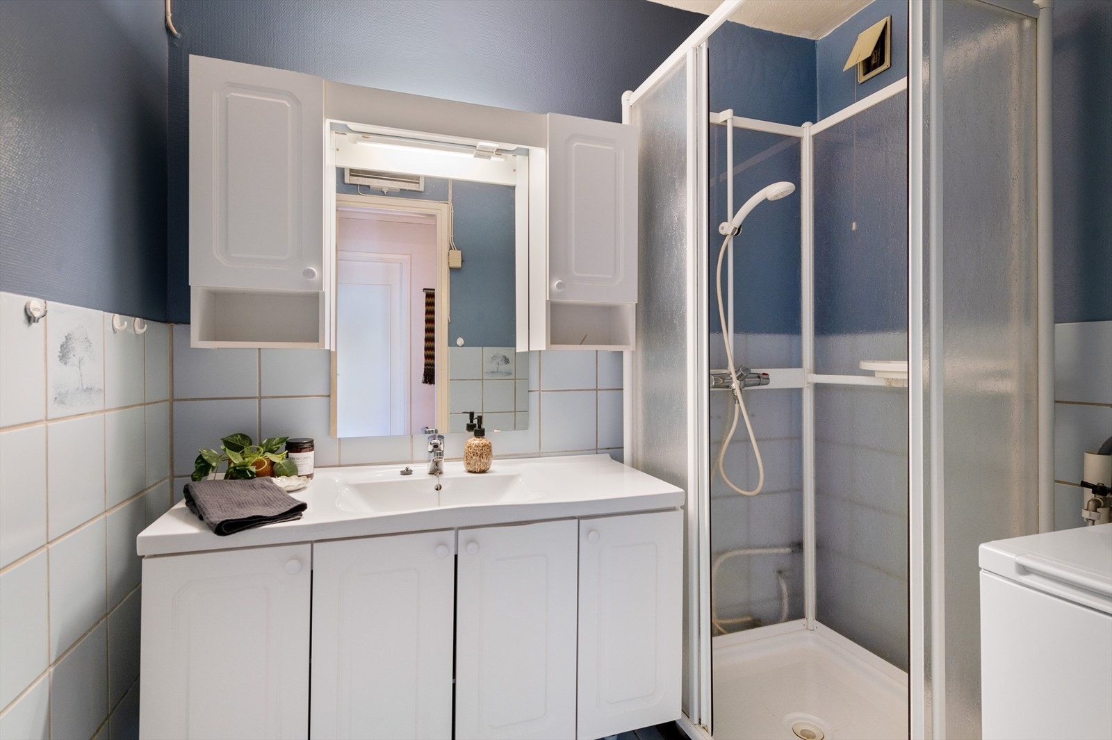 Eldre bad med som på kort sikt er modent for modernisering. Innredning med servant, dusjkabinett og opplegg for vaskemaskin. Galleribilde