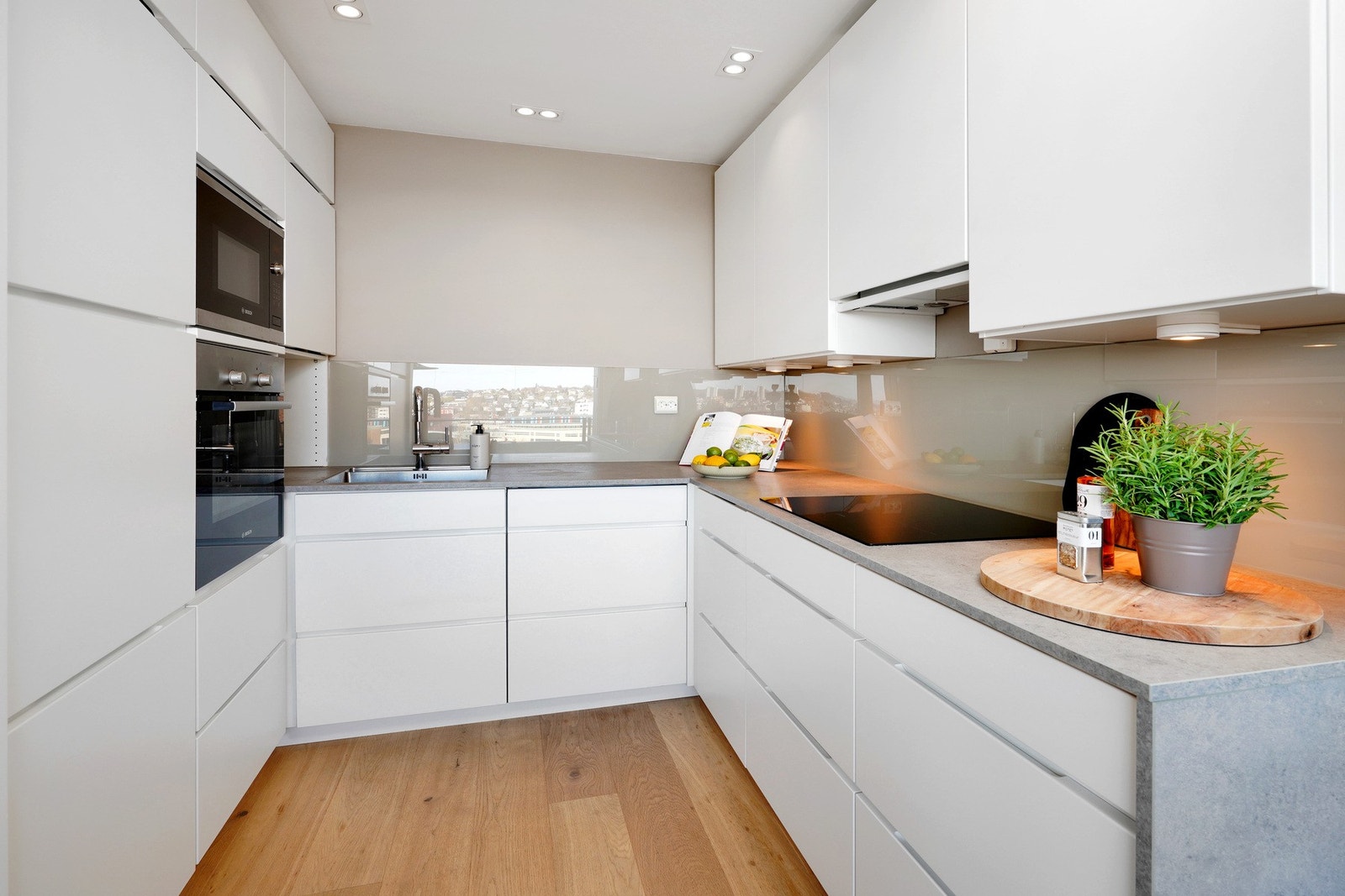 Lyst nøytralt kjøkken byr på rikelig med skap og benke-plass. Galleribilde