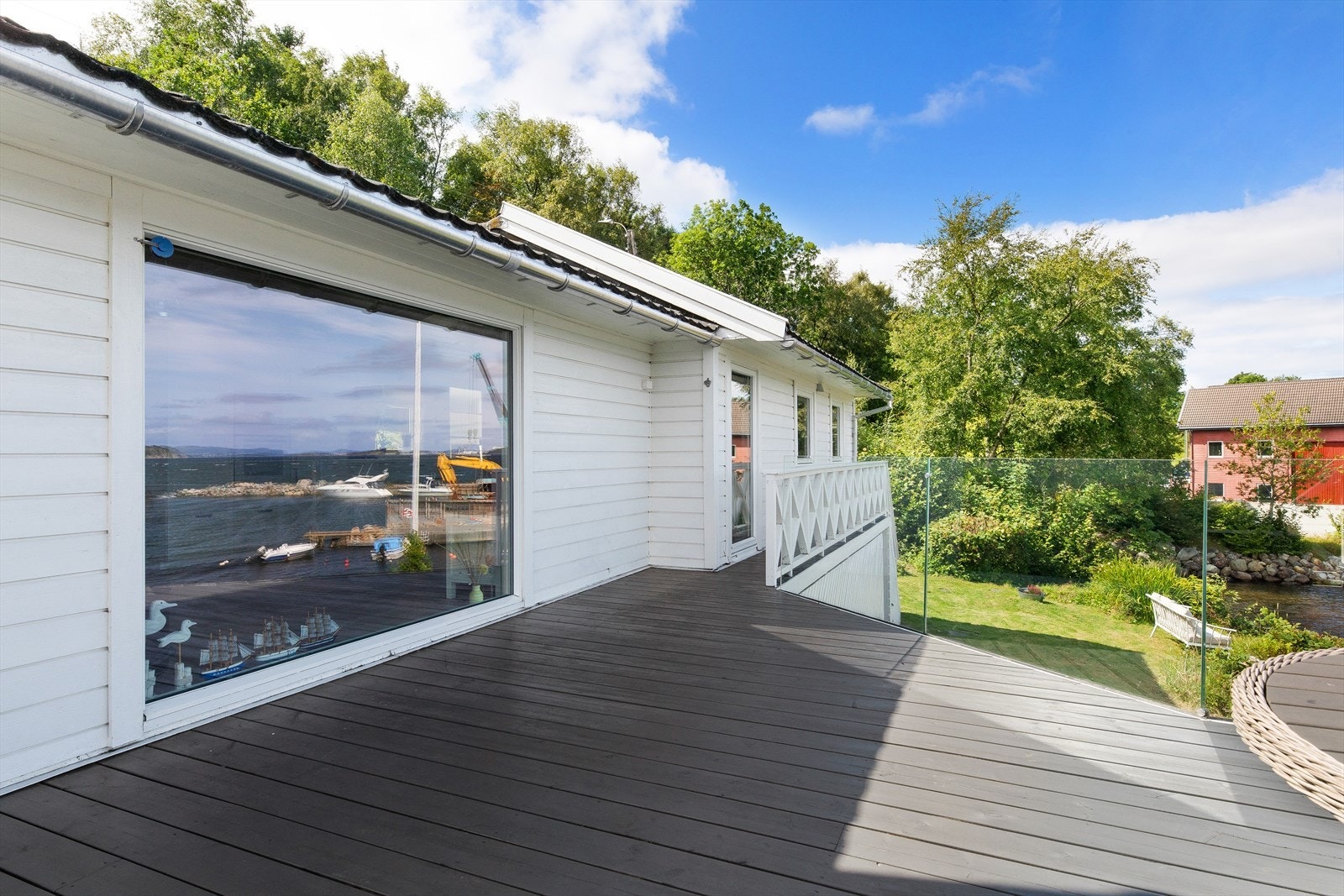Fra terrassen fører en trapp ned til den pent opparbeidede hagen med gressplen, som gir en flott ramme rundt eiendommen. Galleribilde