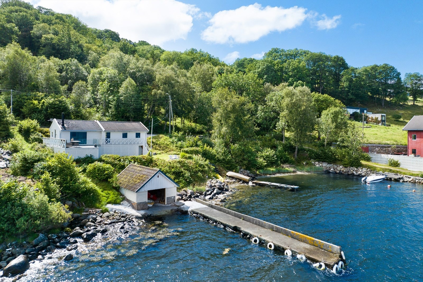 Sjøboden med tilhørende brygge hører til en annen eiendom og medfølger ikke handelen. Galleribilde