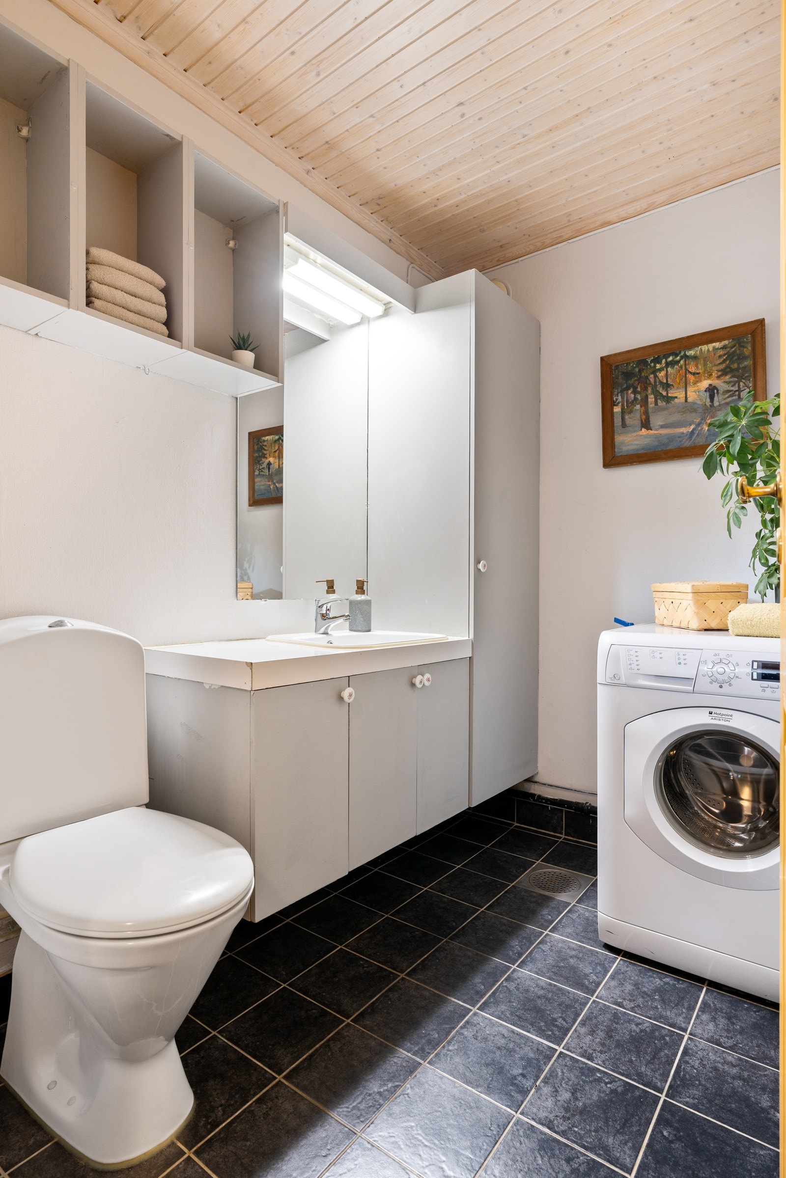 Fra entréen er det adkomst til et praktisk vaskerom, utstyrt med opplegg for vaskemaskin, toalett og en romslig baderomsinnredning med mye oppbevaringsplass. Galleribilde