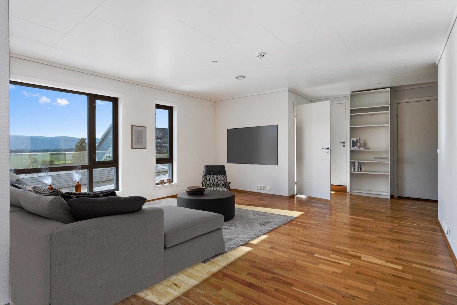 Stuen med 3-stavs eikeparkett, lysmalt gips på vegg og takess i tak. Galleribilde