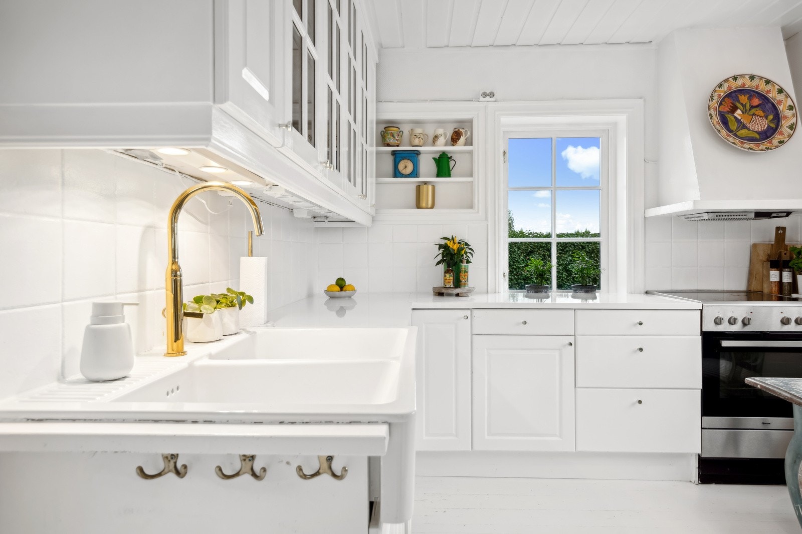 Kjøkkeninnredningen er bestående av malte profilerte fronter, overskap med belysning og laminert benkeplate med dobbel keramisk oppvaskkum med ett-greps armatur. Det er frittstående komfyr, side by side kjøleskap med fryser og dispenser, og oppvaskmaskin. Galleribilde