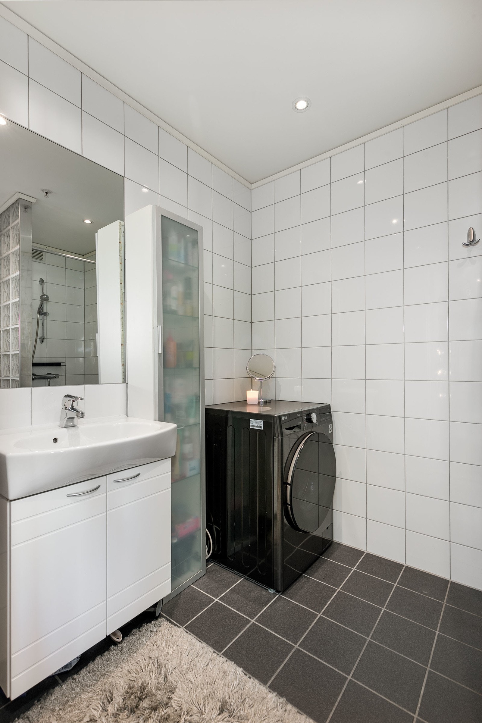 Flislagt bad fra byggeår med gulvvarme. Innredningen består av benkeskap med profilerte fronter og høyskap med frostet dør. Speil over servant og downlights i himling. Galleribilde