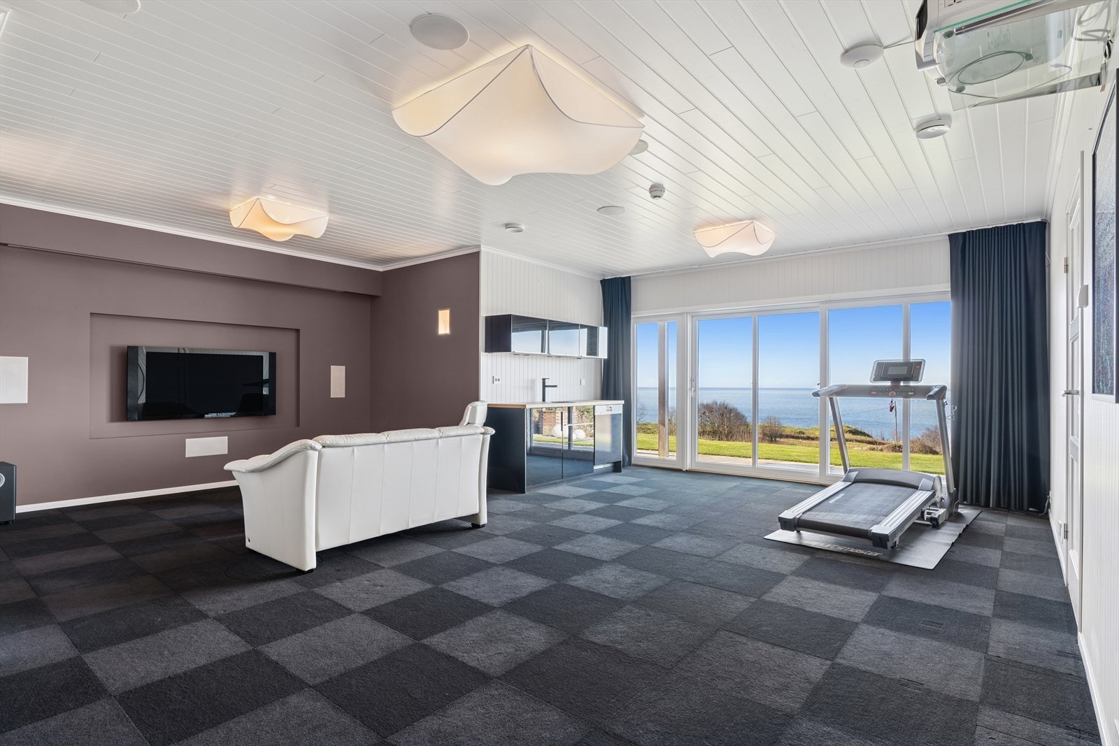 Her finner du et ekstra oppholdsrom som kan tilpasses etter eget behov- brukes i dag som kino. Her har du også tekjøkken m/ oppvaskmaskin, kjøleskap og vask. Galleribilde