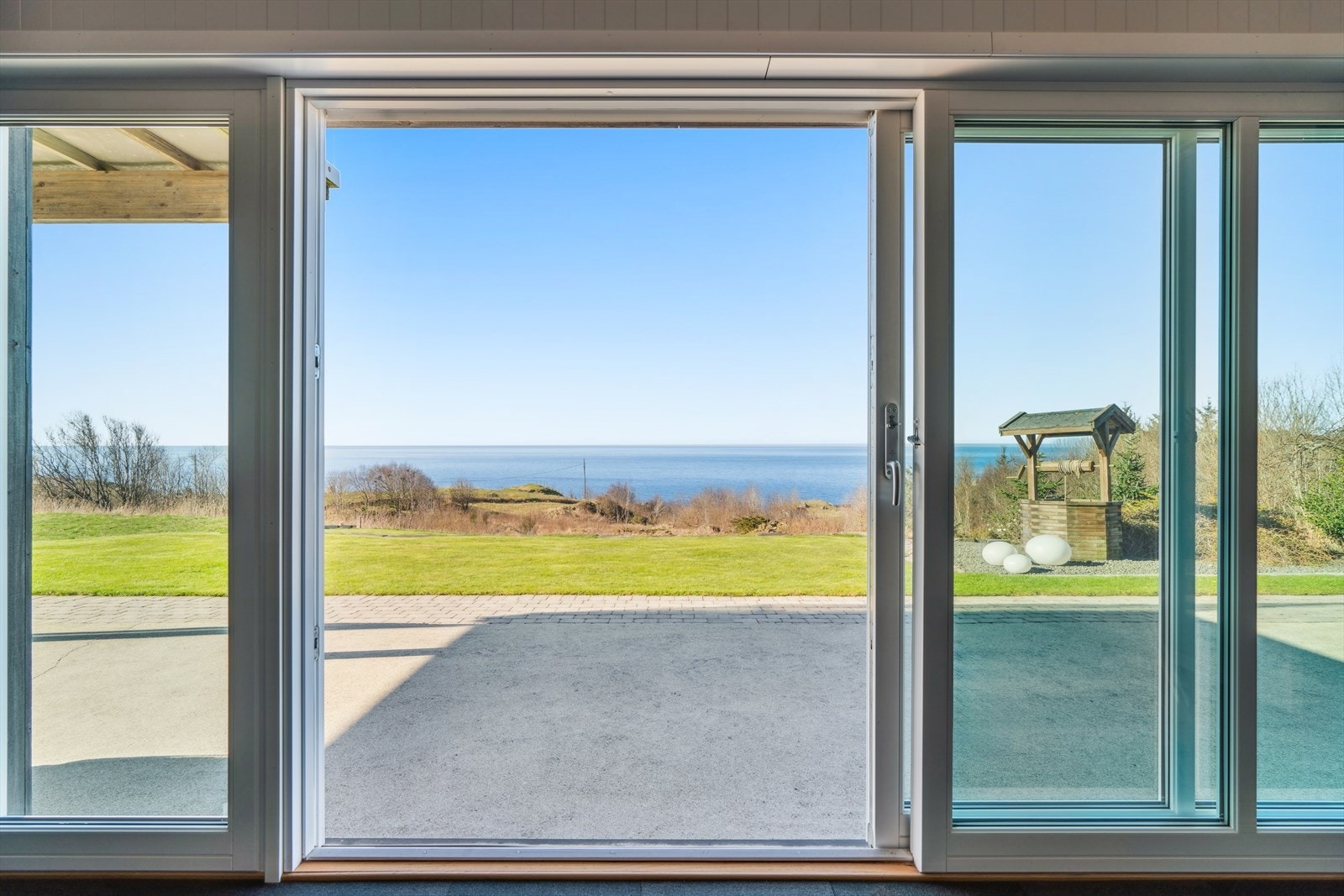 Fra dette rommet er det en stor skyvedør som leder ut til hjemmets uteområde og hage. Galleribilde