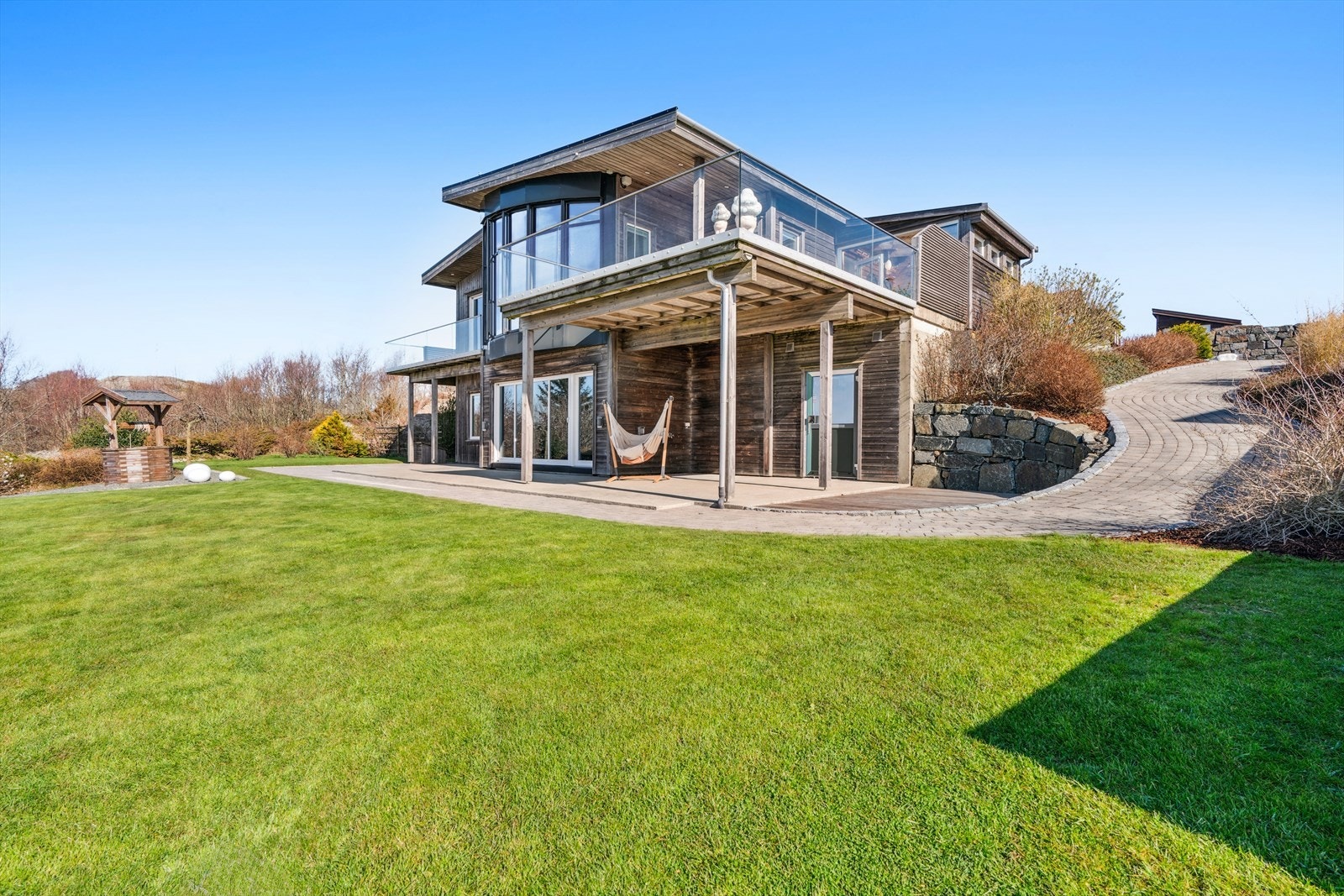 Belegningssteinen og natursteinmurer er benyttet flere steder rundt tomten for å skape en helhetlig og elegant uteflate. Galleribilde