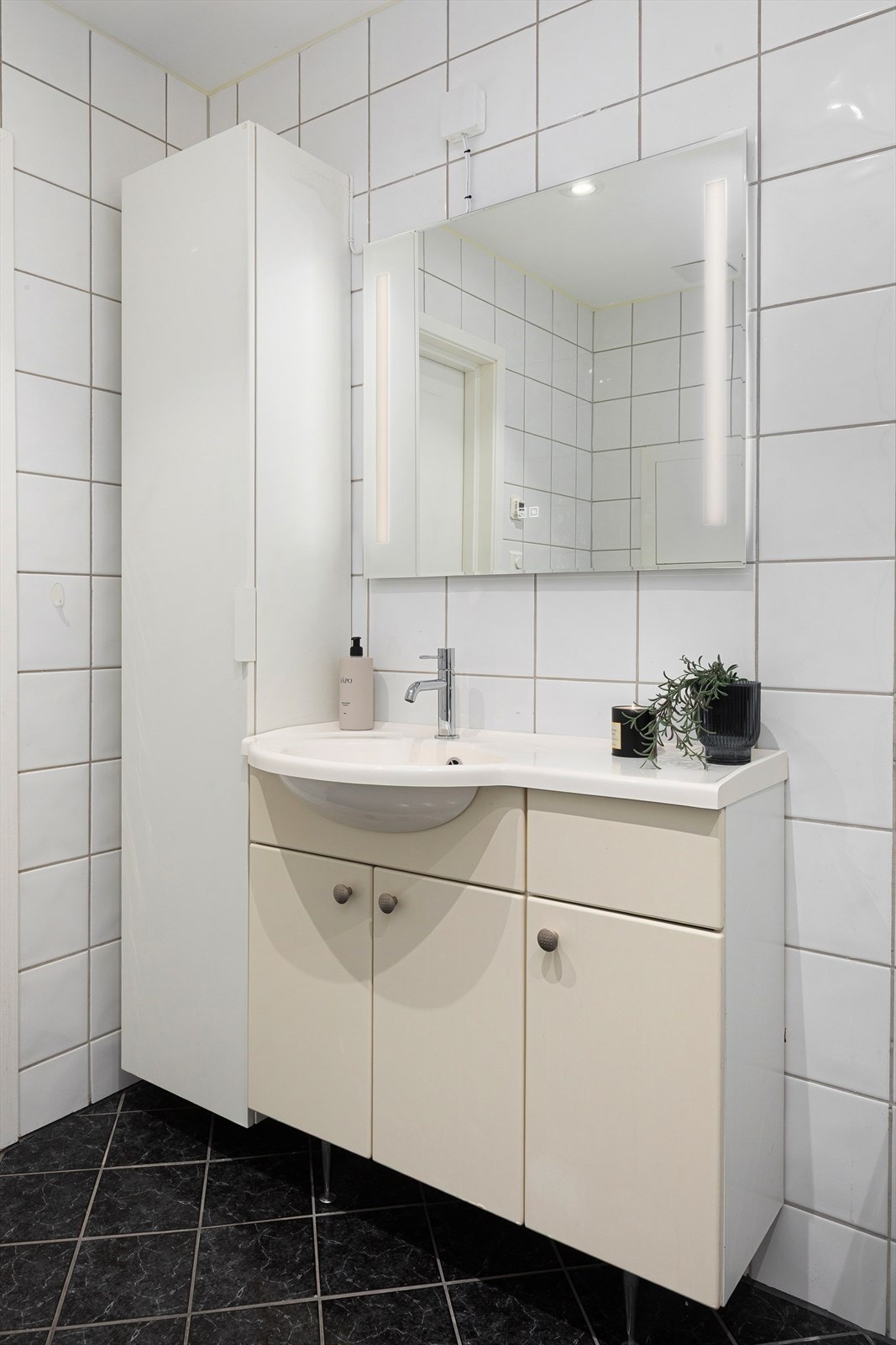 Badet er utstyrt med servant med underskap, speil med lys, dusjnisje og toalett Galleribilde