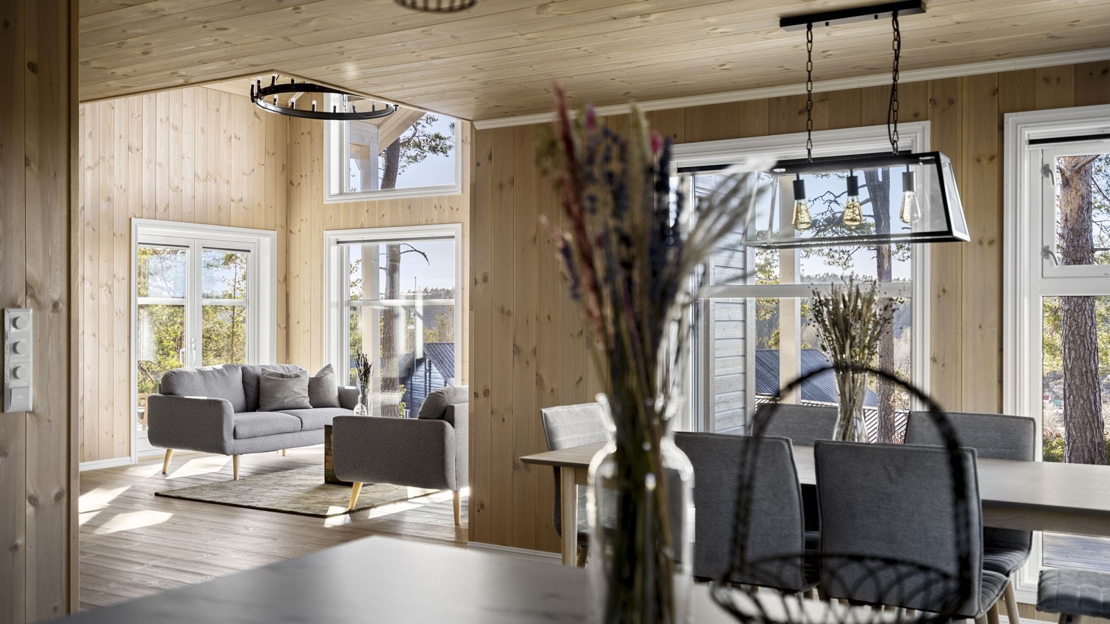 Fra kjøkkenøyen har man utsyn mot stuen og gjestene Galleribilde