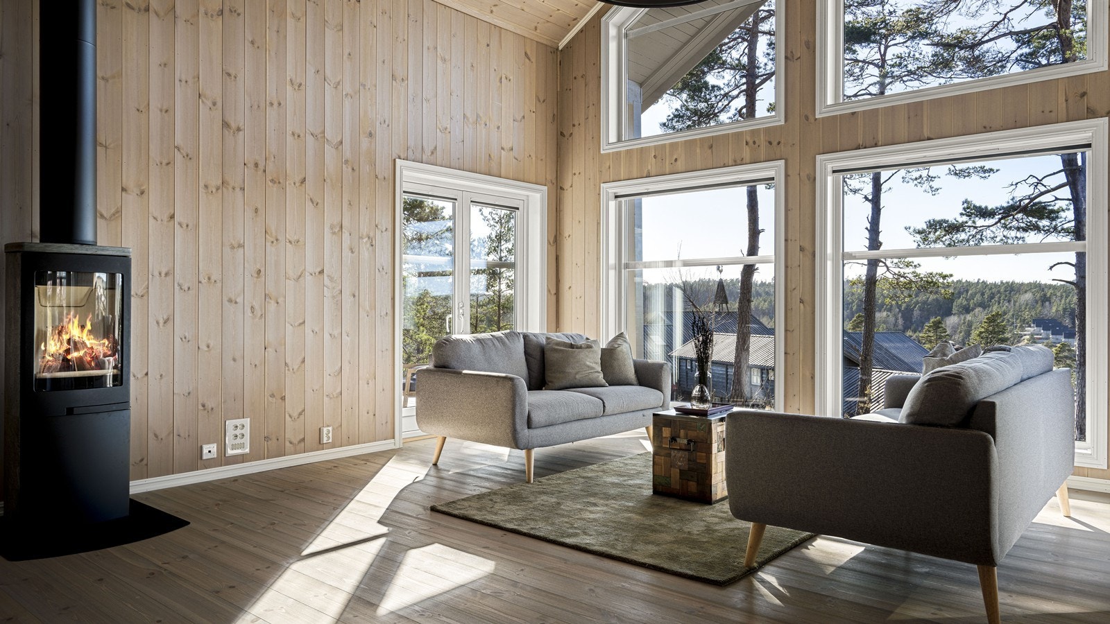 I stuen er det høyt under møne med store vindusflater som slipper inn mye naturlig lys og naturen Galleribilde