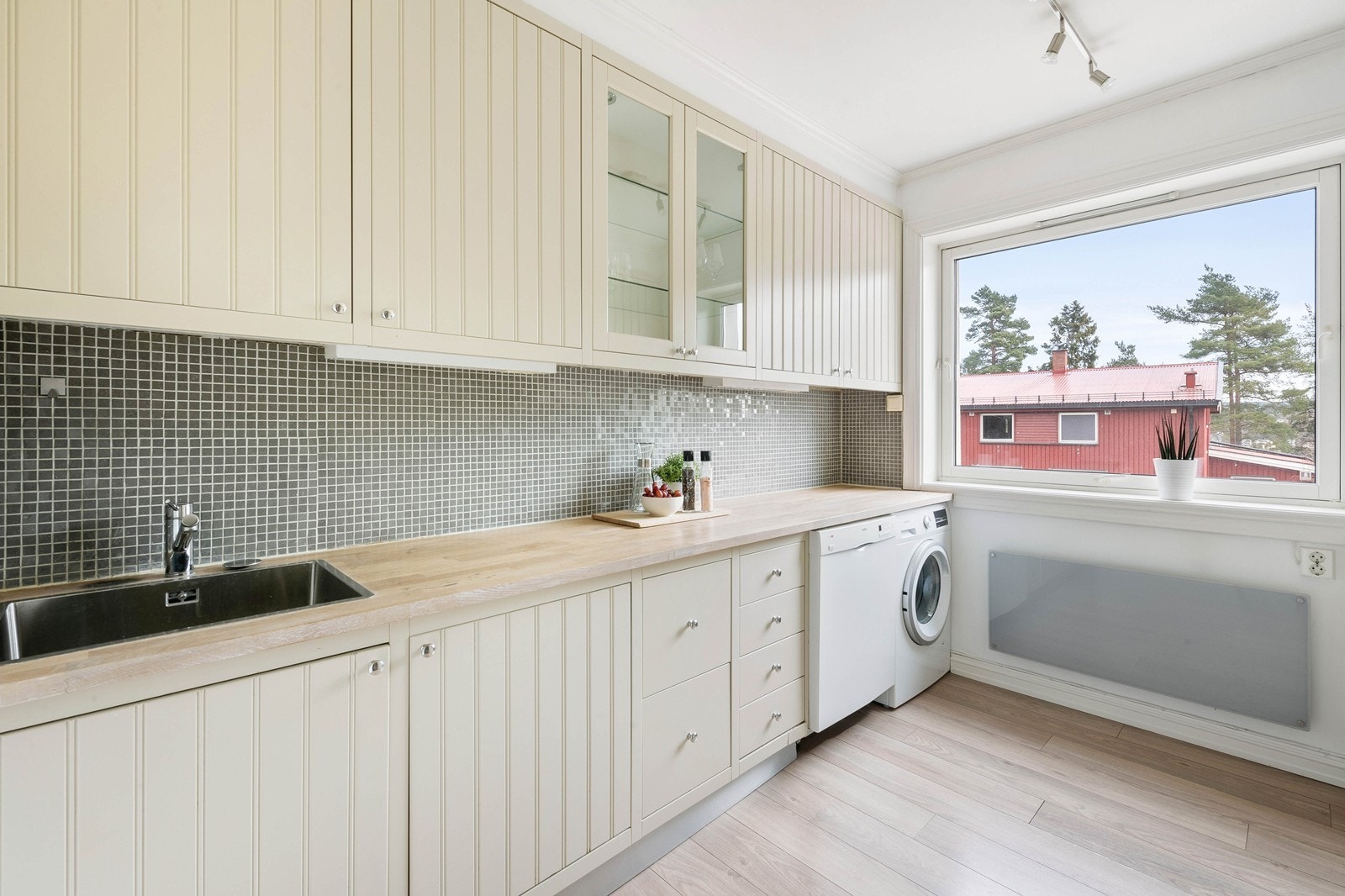 Lyst og pent kjøkken i separat rom Galleribilde