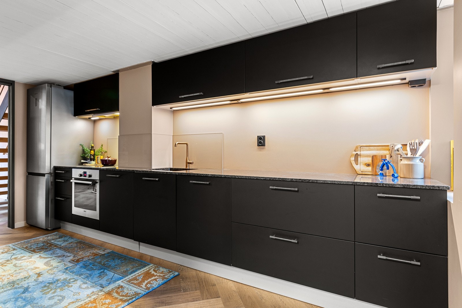 Innbydende, pent Varenna kjøkken fra 2007 med malte fronter i 2023, som har delvis åpen løsning mot stuen Galleribilde