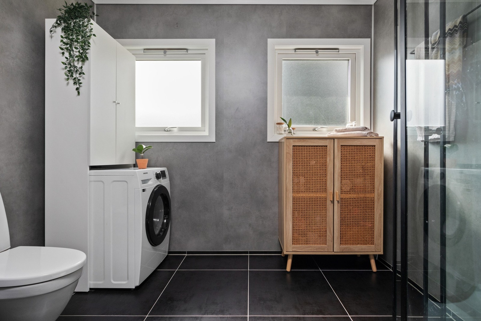 Badet ble pusset opp i 2021, innredet med store, sorte gulvfliser og grå våtromsplater på veggene. Galleribilde