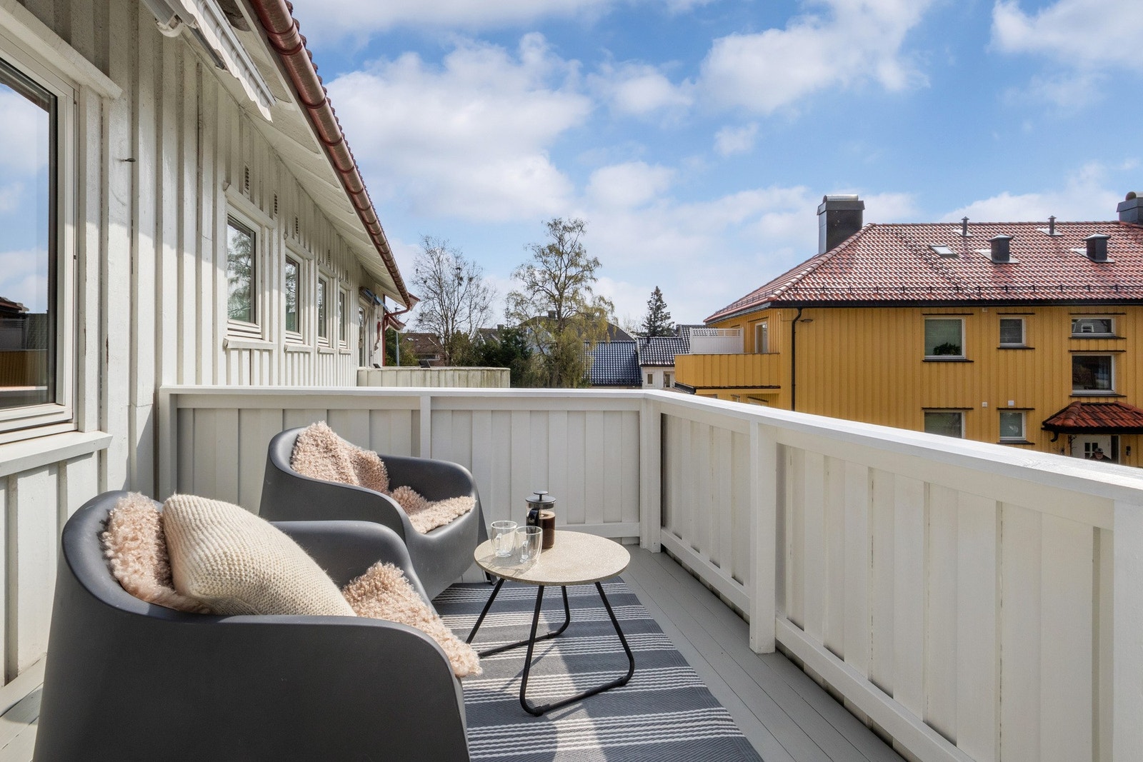 Utenfor stuen nytes varme dager på en solrik og romslig balkong med nyere markise. Galleribilde