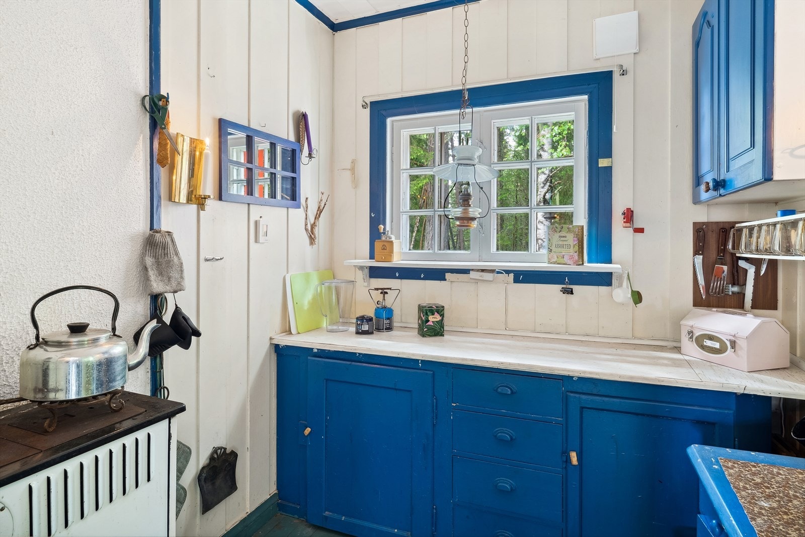 Kjøkkenet har malt blå innredning. Galleribilde