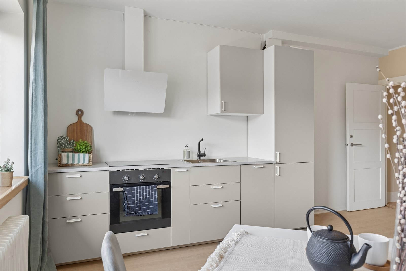 Praktisk utforming med lyse fronter og gode løsninger for både oppbevaring og arbeid. Galleribilde