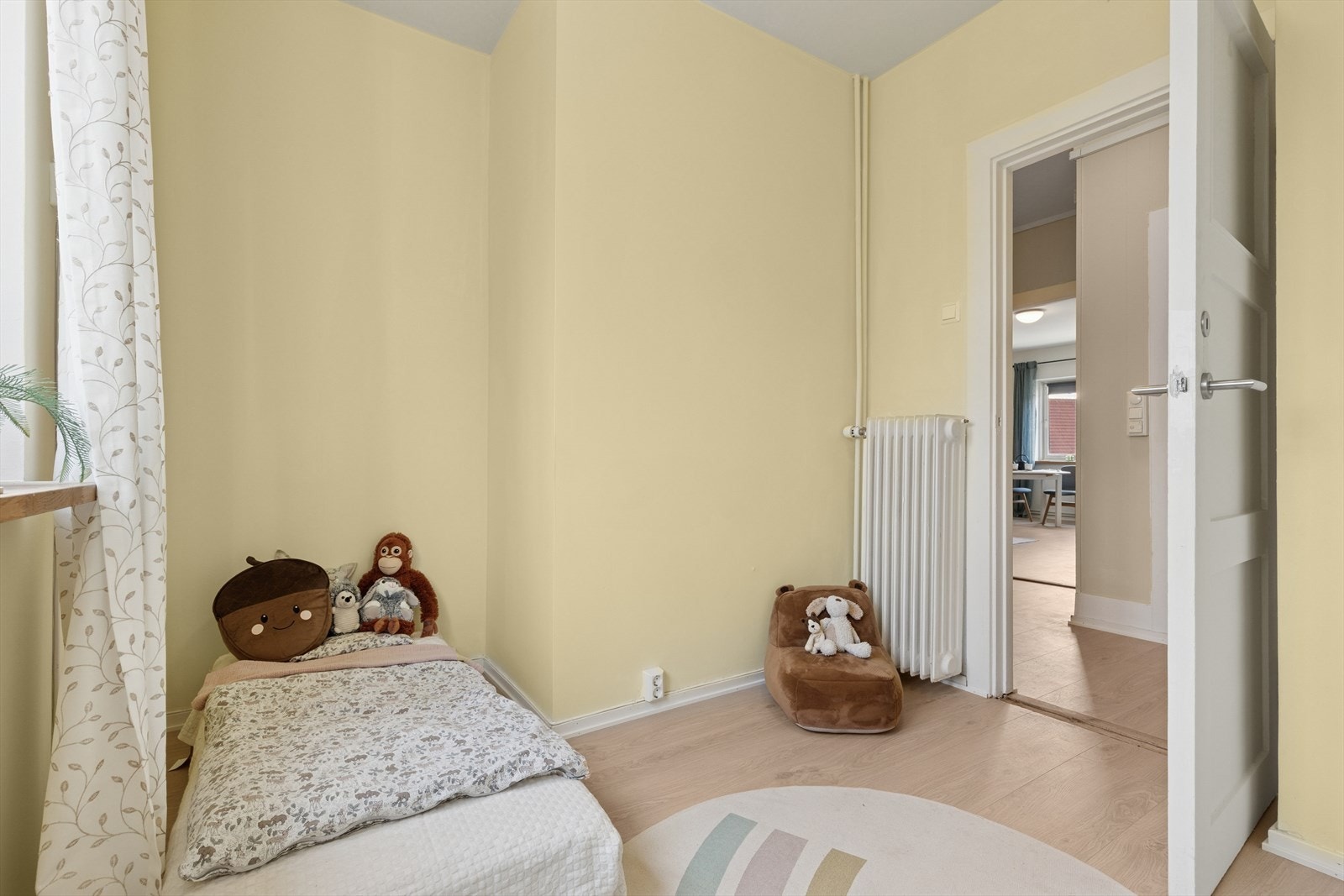 Rommet er malt i en varm og innbydende lysegul farge som gir en koselig og rolig atmosfære, perfekt for hvile og avslapning. Galleribilde