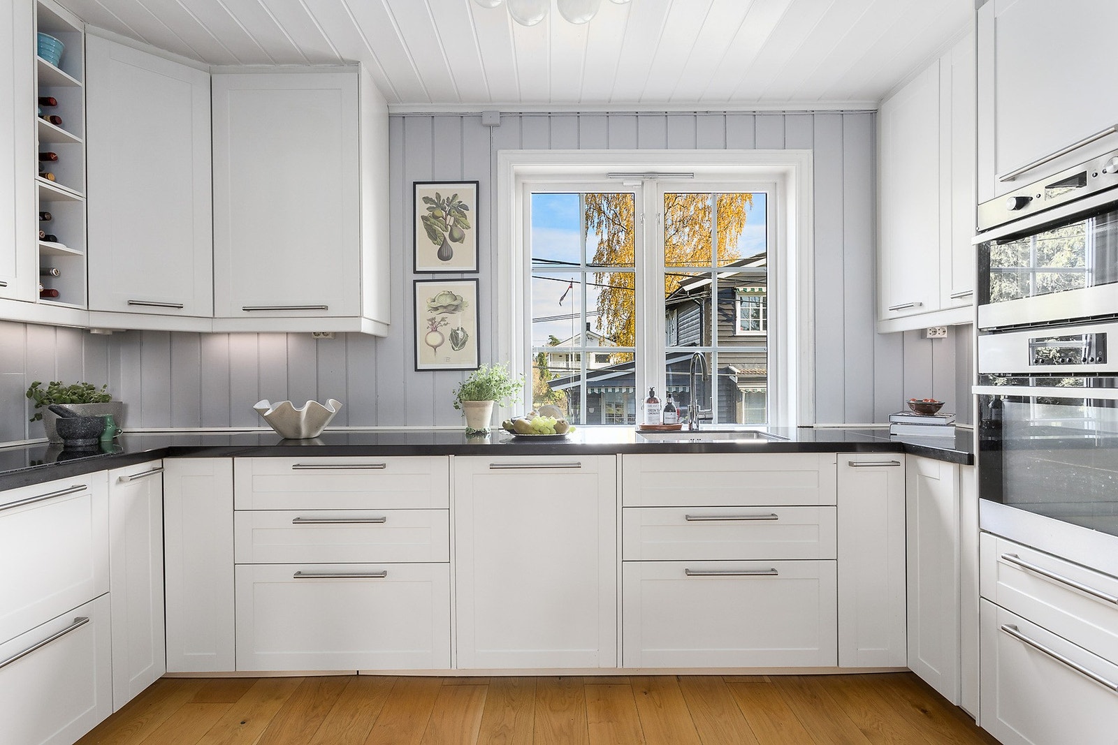 Kjøkkeninnredning fra 2014 med hvite, profilerte fronter og benkeplate av laminat Galleribilde
