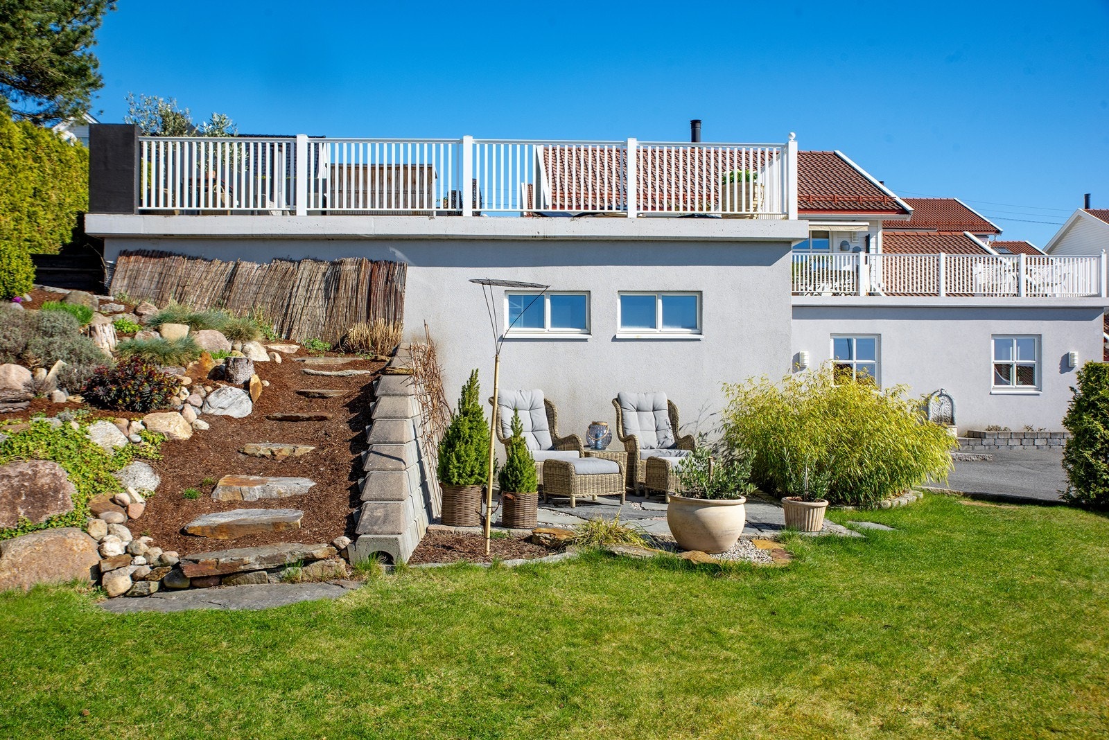 Fra takterrassen er det laget til en en steintrapp ned til boligens hage og steinbelagt uteplass i solveggen. Galleribilde