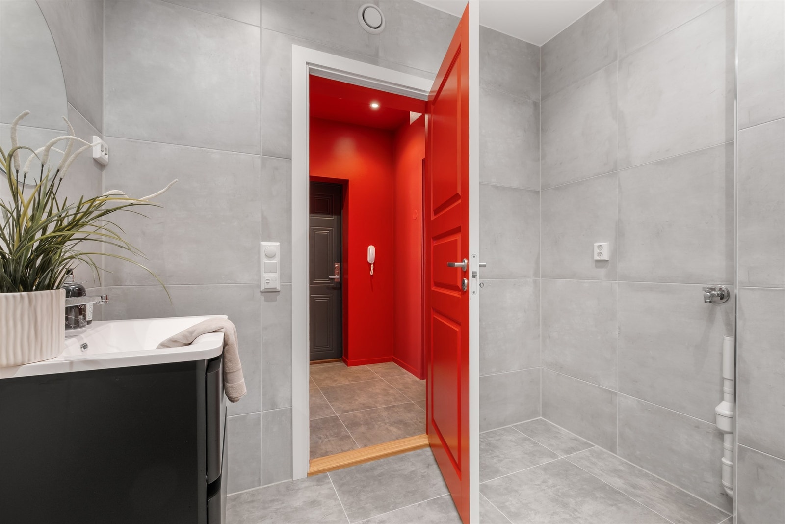 Videre er badet utstyrt med servantskap med speil, vegghengt toalett og dusjhjørne. Galleribilde