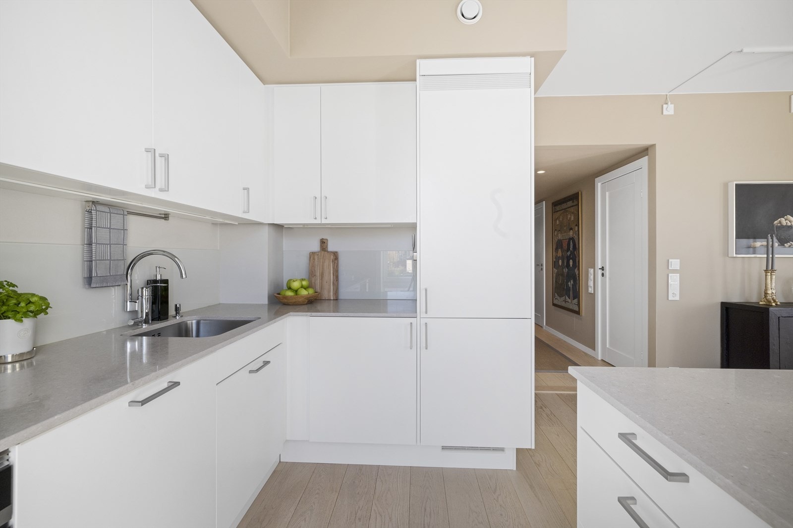 Flott innredning med hvite fronter og benkeplate av steinkompositt Galleribilde