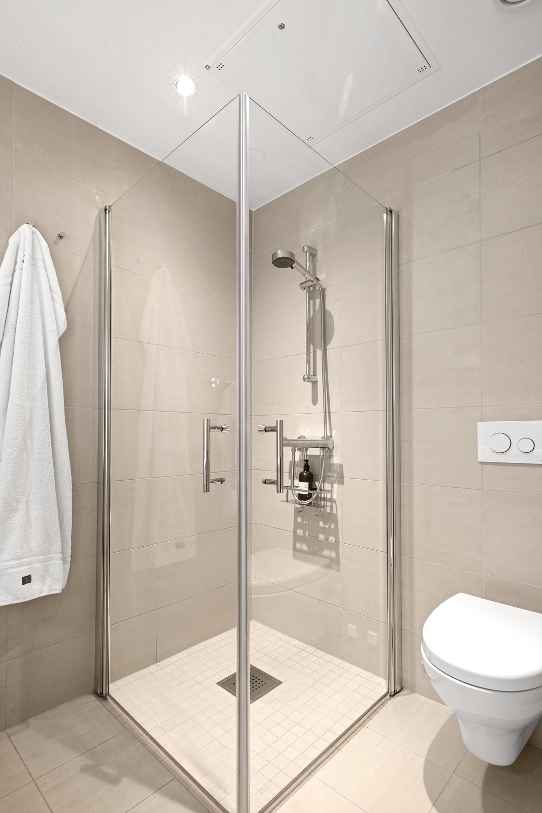 Badet er utført i moderne fliser og delikate fargevalg Galleribilde