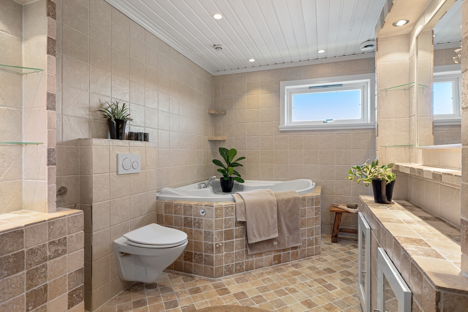 Badet er helfliset og lekkert, med varmekabler i gulvet og innfelte downlights i himlingen. Galleribilde