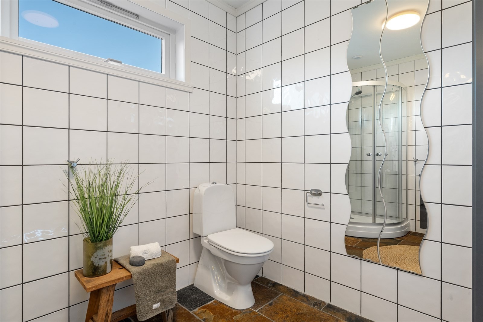 Det har flislagte overflater og er utstyrt med dusjkabinett, baderomsinnredning med dobbel servant og toalett. Galleribilde