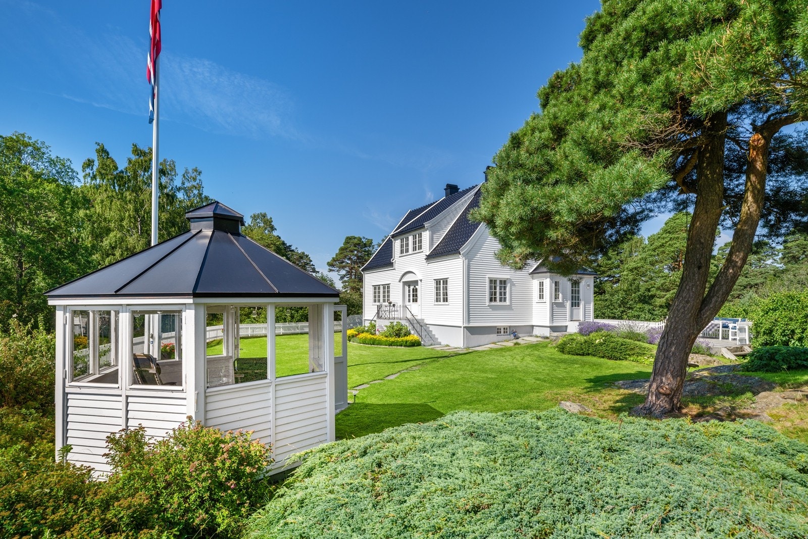 Eiendommen er innrammet med en praktfull hage på en tomt som sømløst går i ett med naturen. Galleribilde