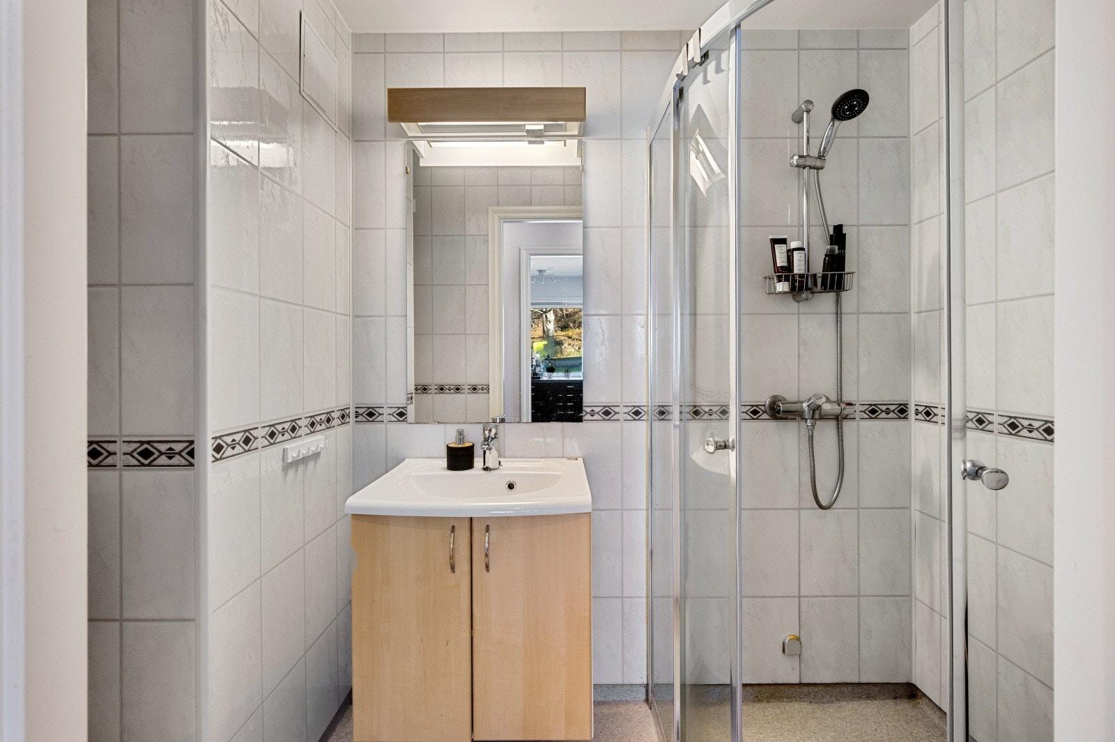 Leilighetens bad har baderomsplater på vegger og vinylbelegg på gulv. Galleribilde