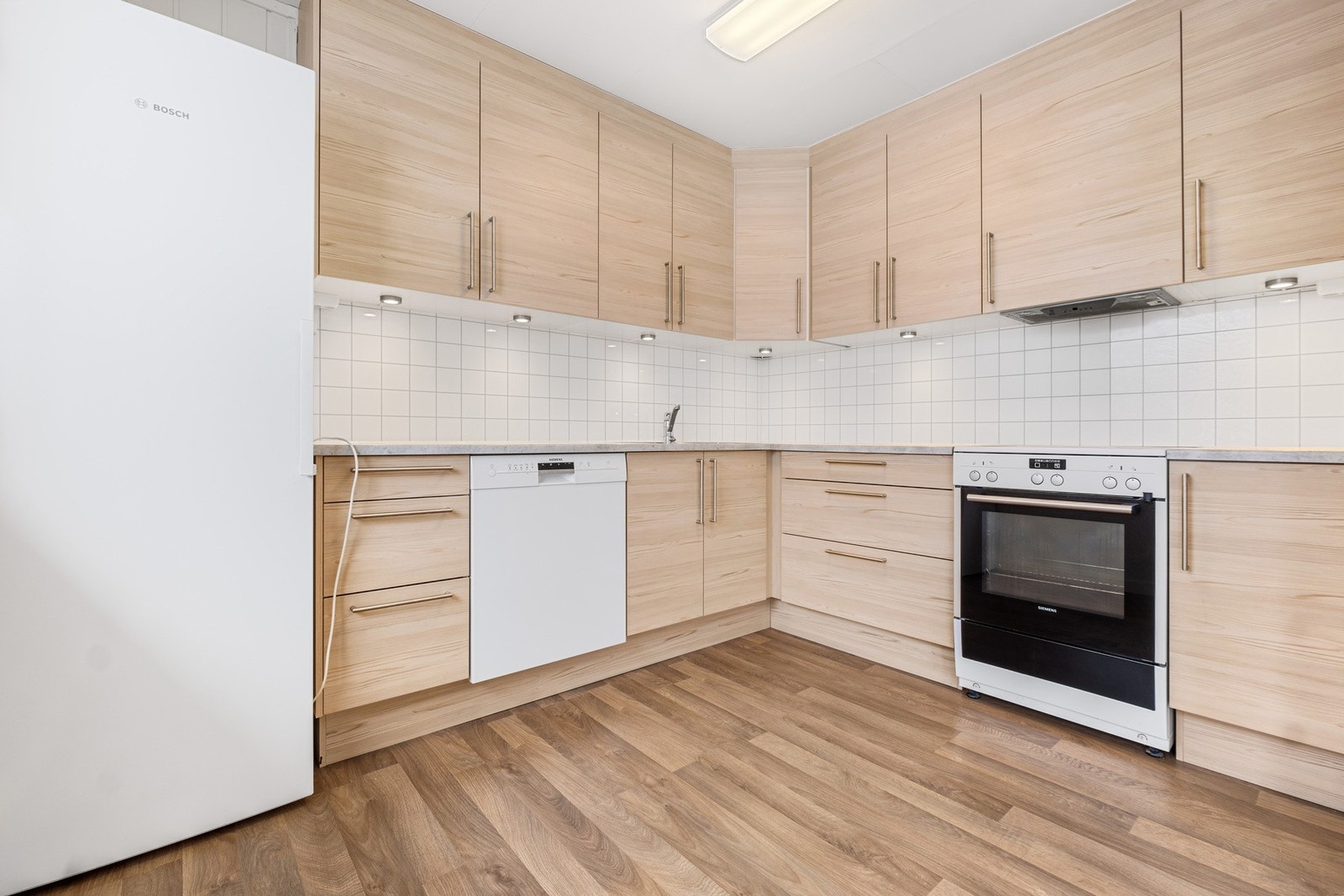 Kjøkkeninnredning med fronter i finert slett utførelse. Galleribilde