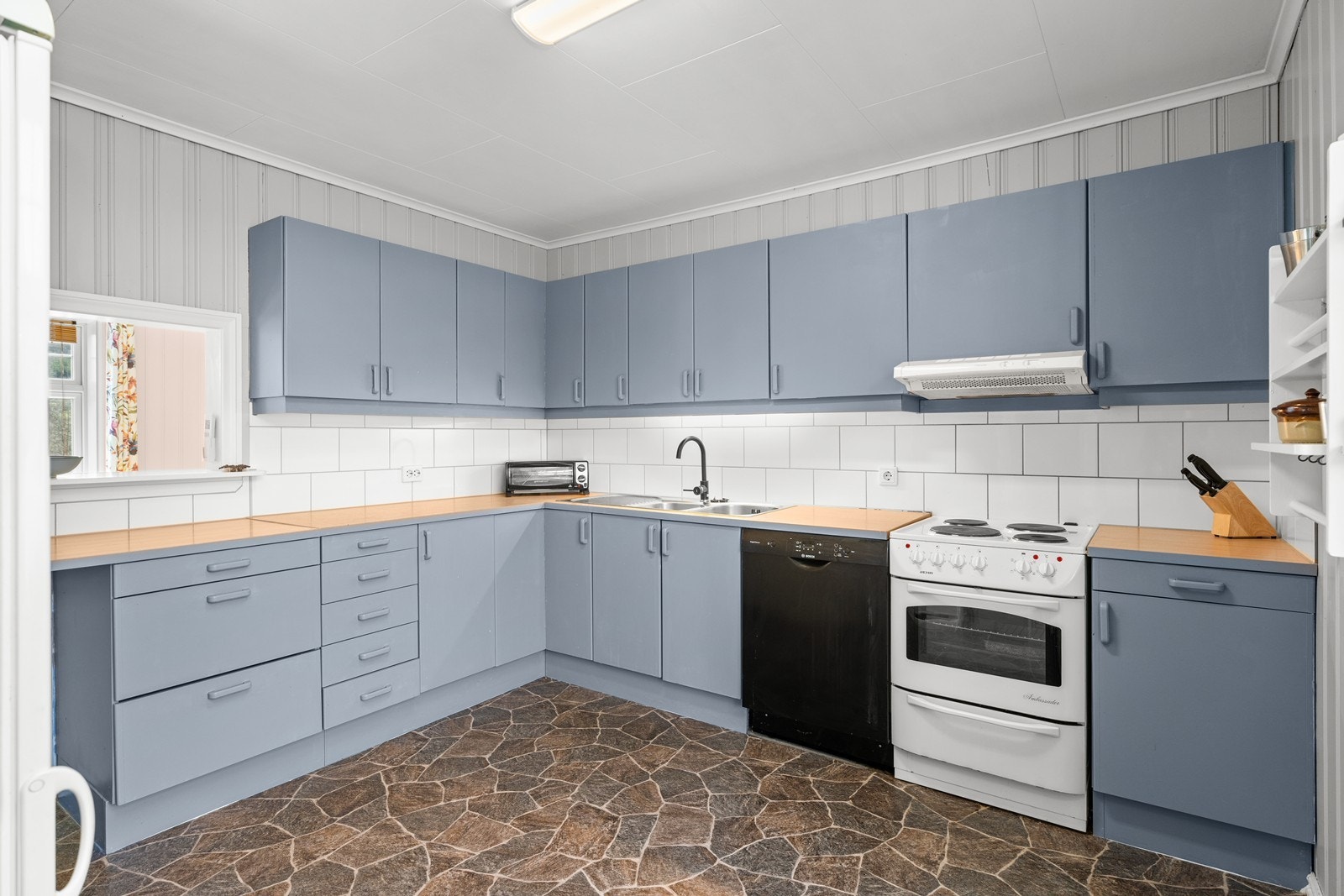 Lyst og romslig kjøkken med moderne løsninger og god oppbevaringsplass. Galleribilde