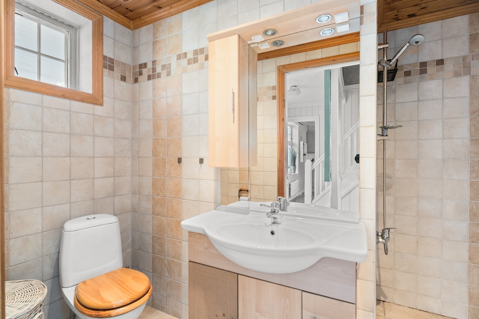 Lyst bad med moderne fliser, praktisk dusjhjørne og toalett. Galleribilde