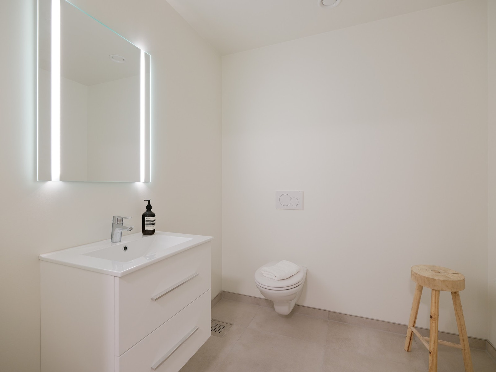 Innredet med vegghengt toalett, servant med skuffer og opplegg for vaskemaskin. Galleribilde