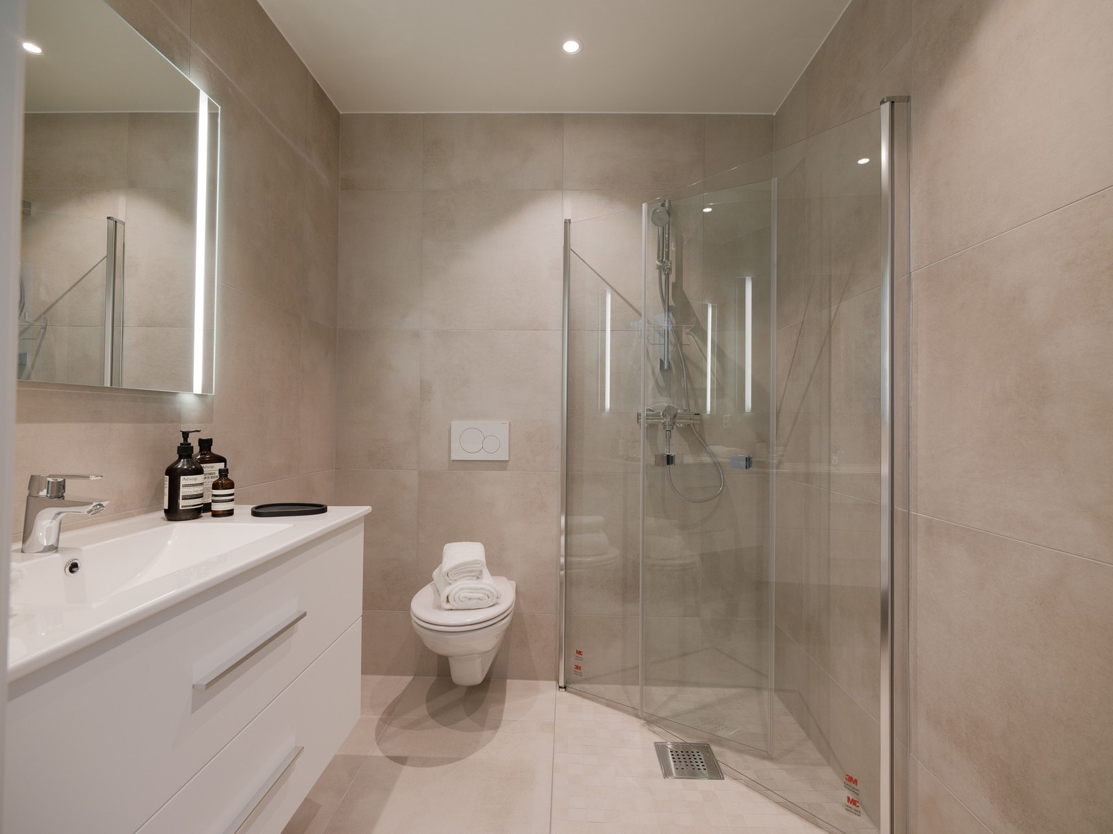 Hovedbad er utstyrt med 80 cm servantmøblel, speil med lys, vegghengt toalett og dusjvegger. Galleribilde