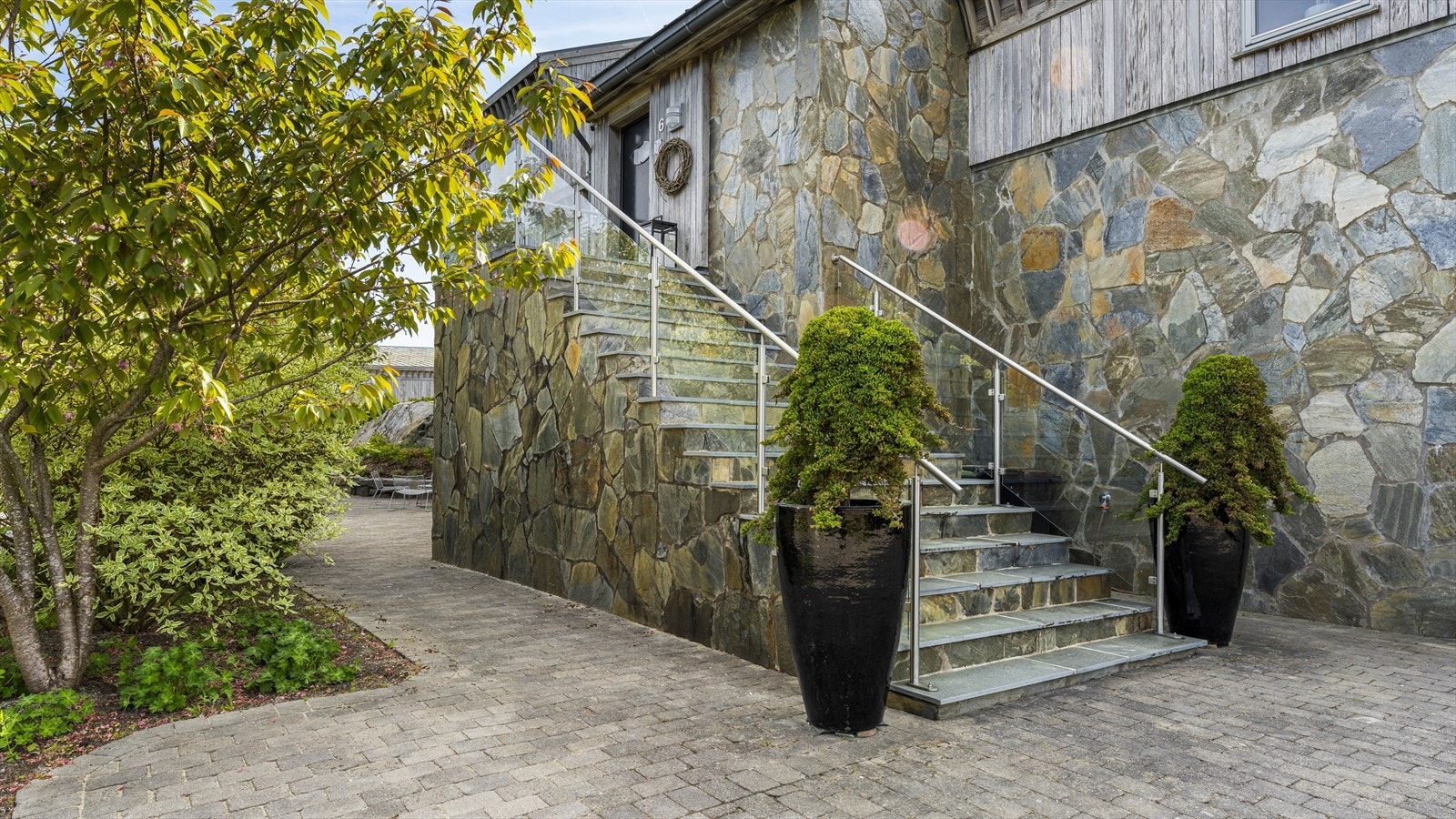 Kombinasjonen av skifer med nydelig fargespill og grånet ospekledning er med på å gi boligen et særpreg som få boliger kan skilte med. Galleribilde