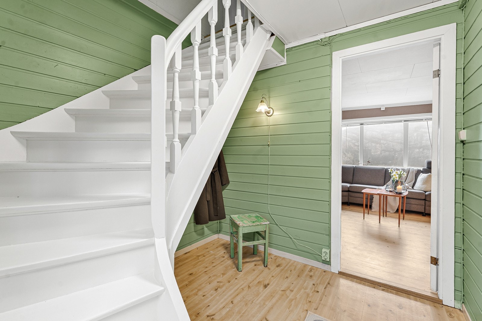 Gangen har malt panel på vegger og belegg på gulv. En hvitmalt trapp leder opp til 2.etasje. Galleribilde