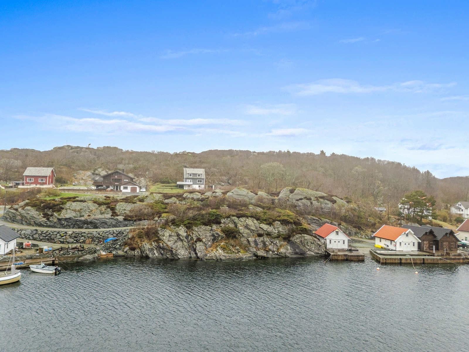 Nausttomten ligger sørvendt og lunt til, på enden av en rekke med naust. Galleribilde